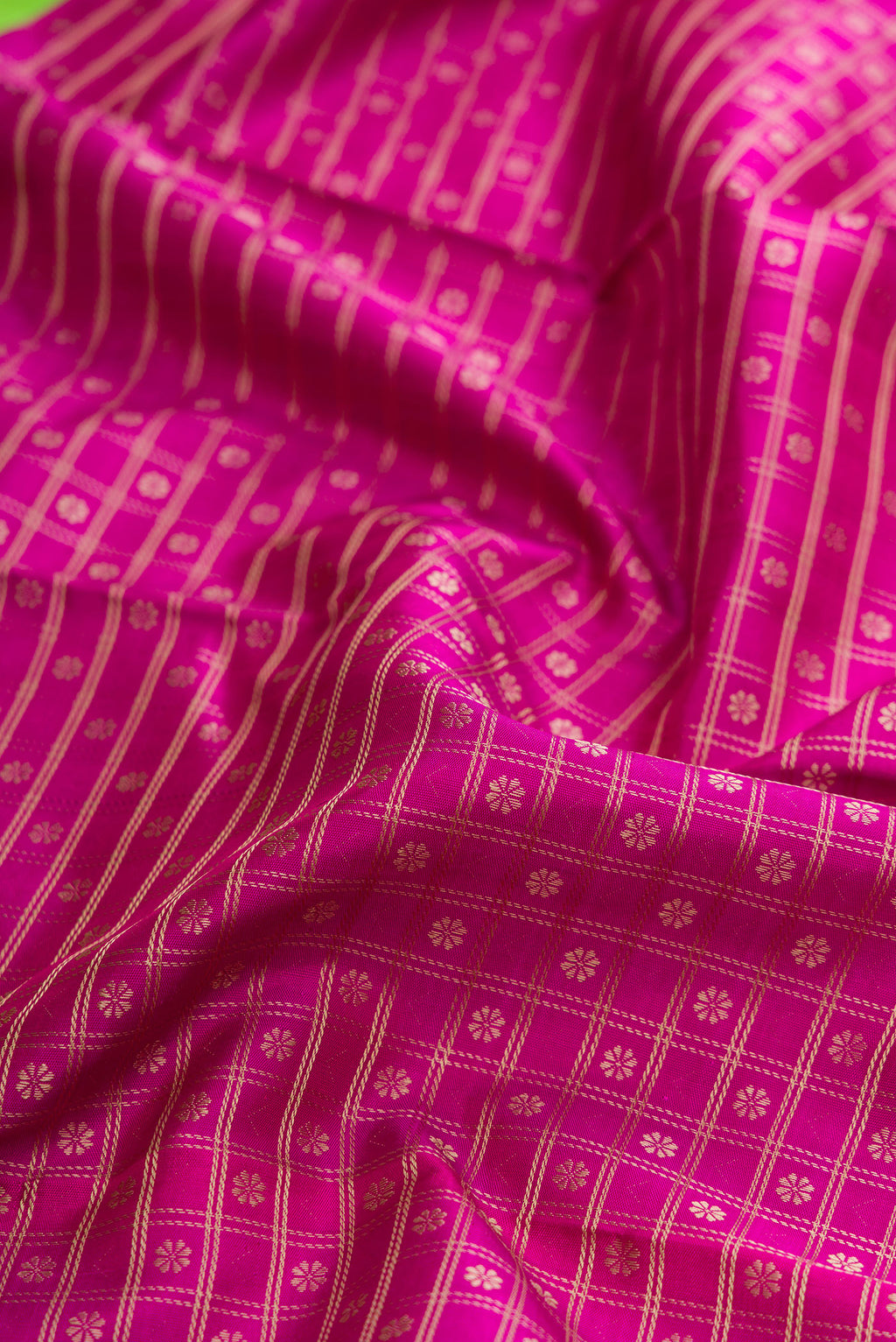 Close up of Pure Silk Pure Zari Magenta Dual Tone Kanjivaram Saree with Zari Brocade on the body and Zari Border.  displaying folds