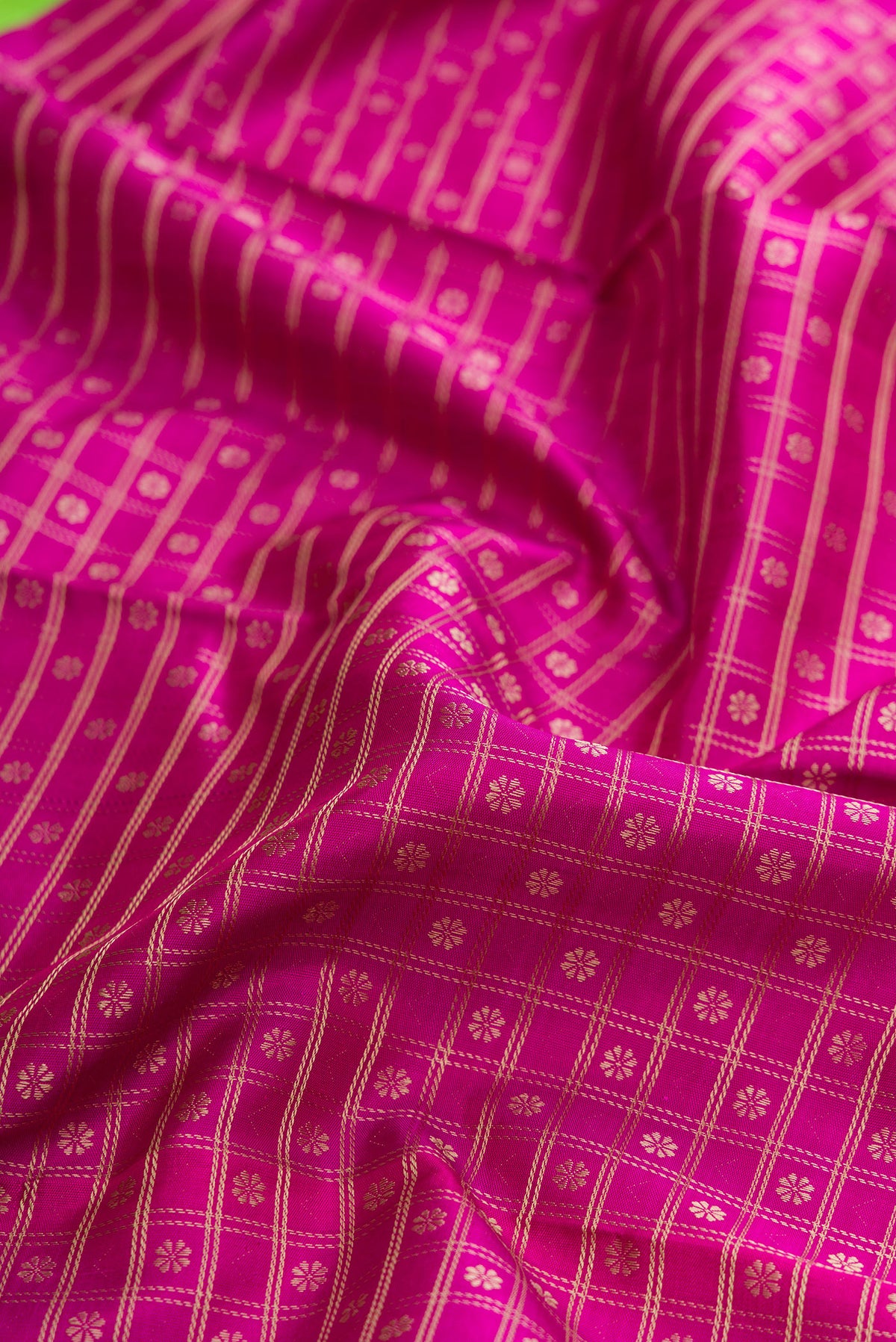Close up of Pure Silk Pure Zari Magenta Dual Tone Kanjivaram Saree with Zari Brocade on the body and Zari Border.  displaying folds