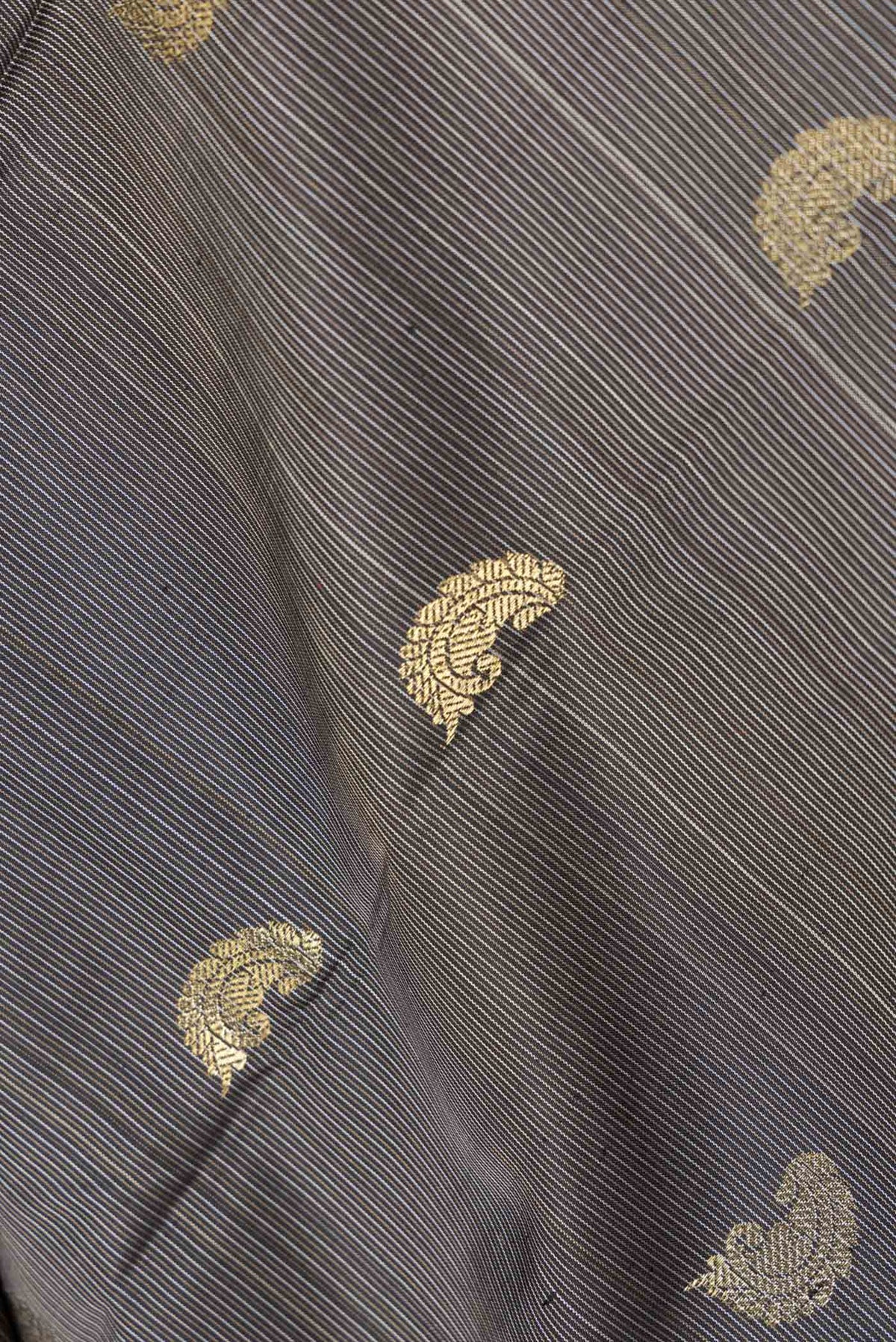 Close up of Black Dual Tone Kanchipuram Saree with Stripes on the body and Zari Border displaying folds