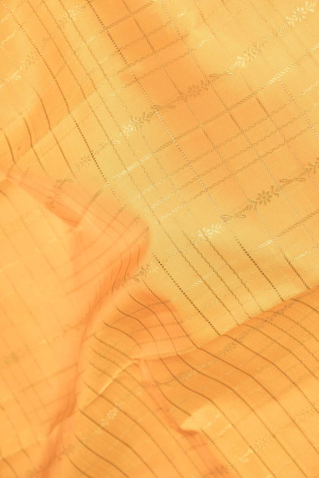 Close up of Pure Silk Pure Zari Orange Dual Tone Kanchipuram Saree with Checked design on the body and Zari Border displaying folds