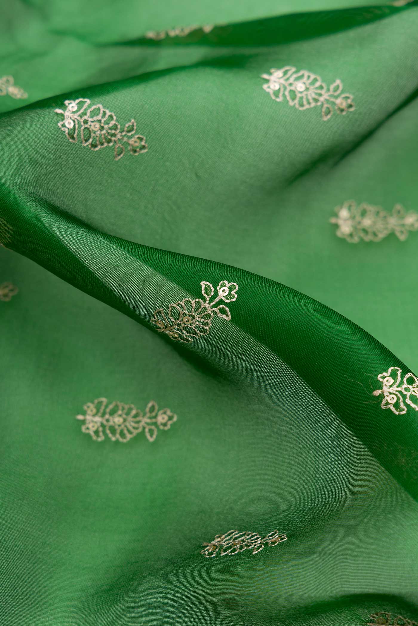 Close up of Bottle Green Dual Tone Organza Silk Saree with Embroidery on the body and Embroidery Border.  displaying folds