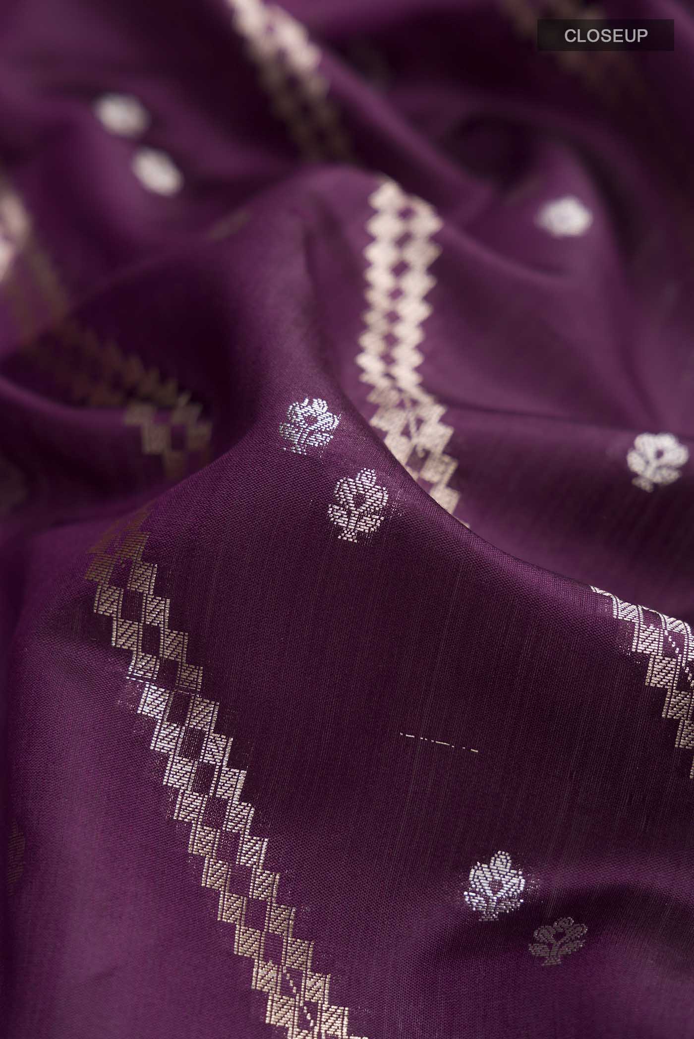 Close up of Purple Banarasi Raw Silk Saree with Zari Butta on the body and Zari Border displaying folds