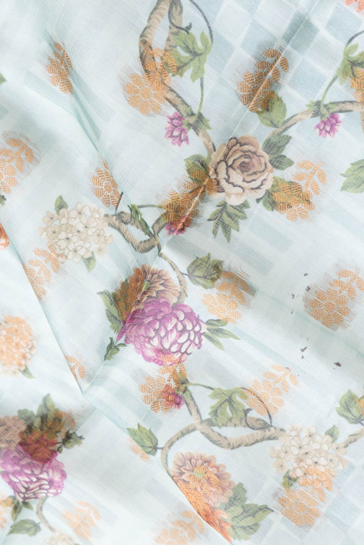 Close up of Sky Blue Dual Tone Tussar Silk Saree with Printed design on the body and Thread Border.  displaying folds