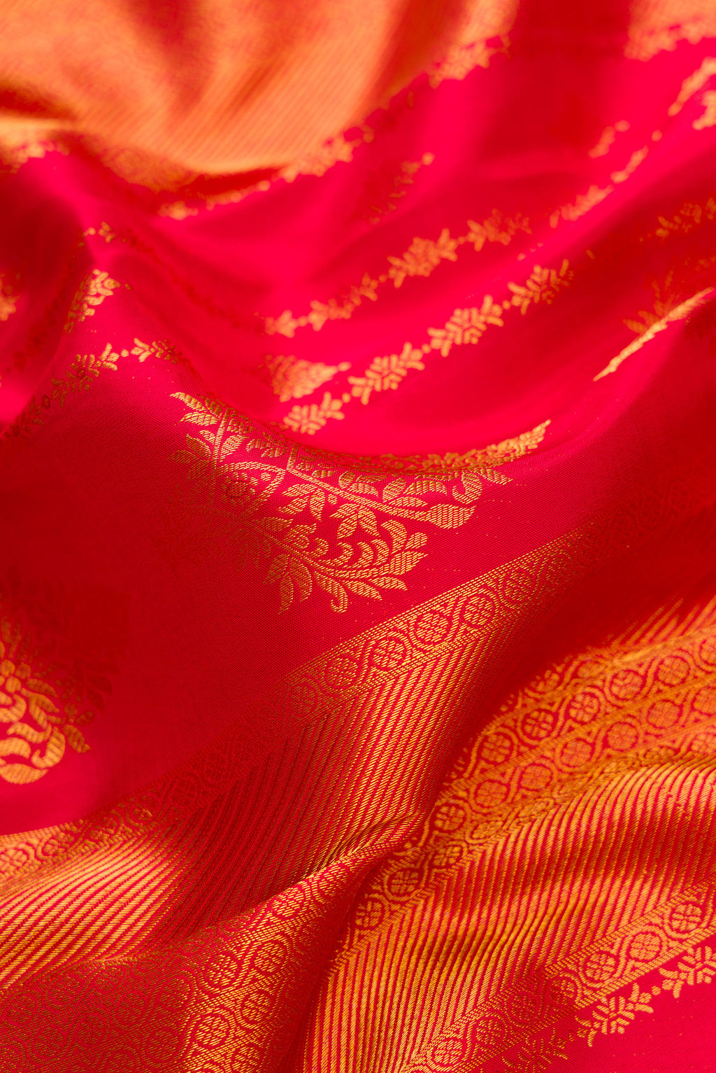 Close up of Dark Pink Dual Tone Kanjivaram Silk Saree with Zari Brocade on the body and Zari Border.  displaying folds