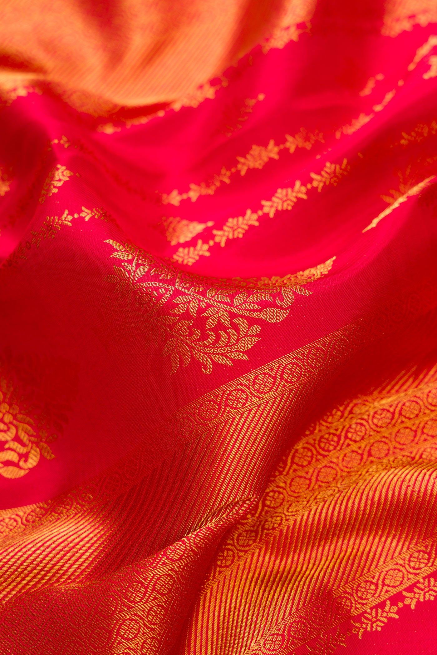 Close up of Dark Pink Dual Tone Kanjivaram Silk Saree with Zari Brocade on the body and Zari Border.  displaying folds