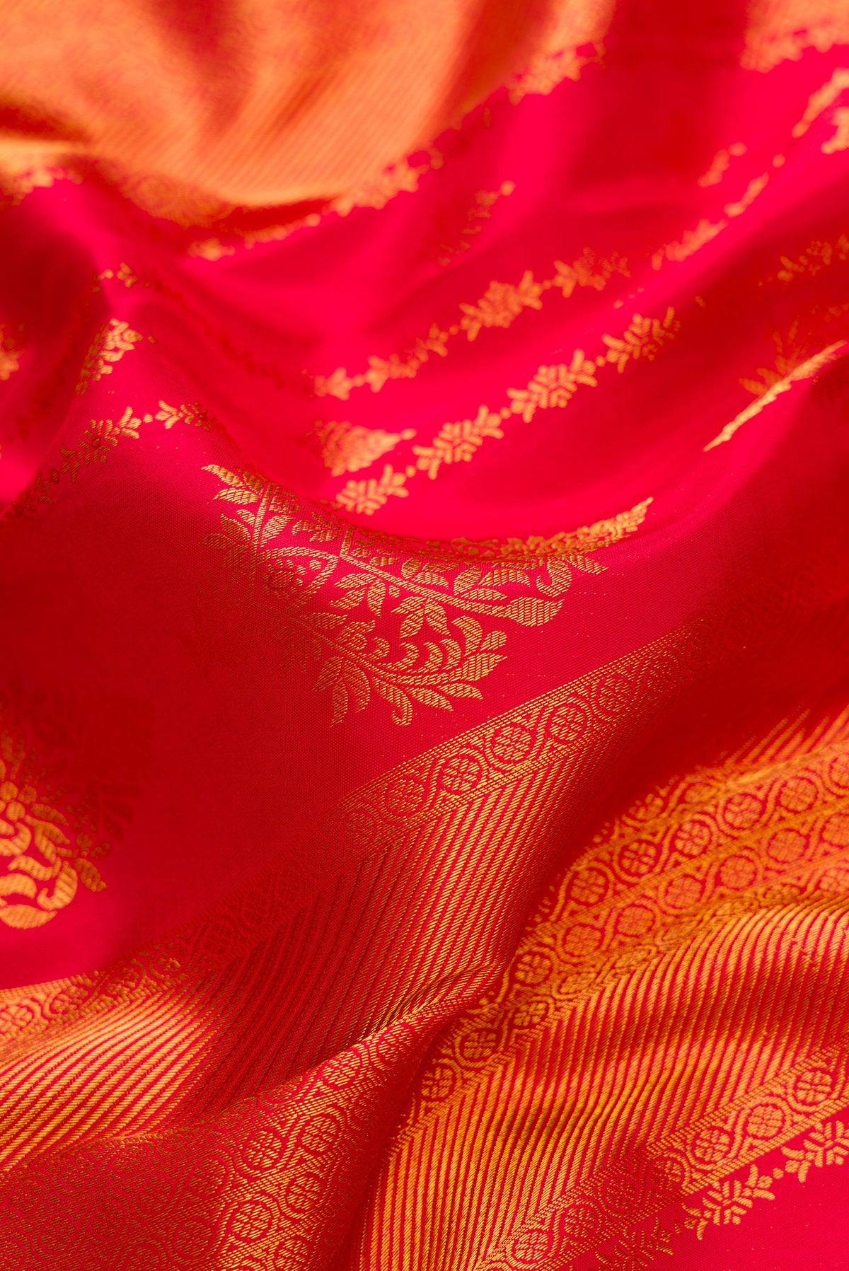 Close up of Dark Pink Dual Tone Kanjivaram Silk Saree with Zari Brocade on the body and Zari Border.  displaying folds