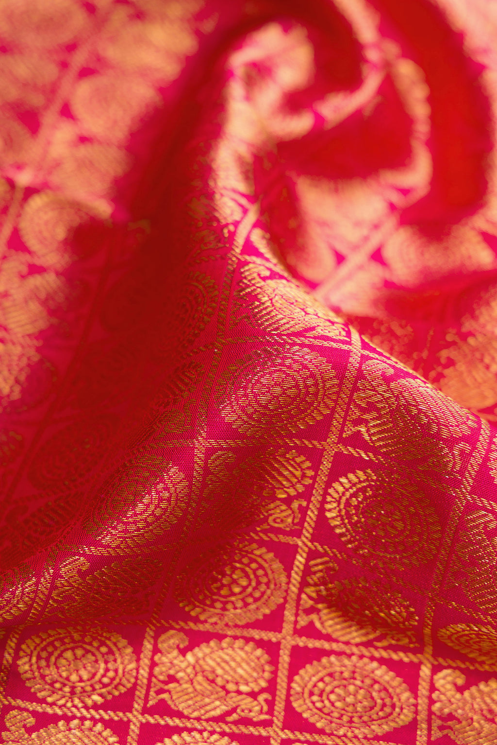 Close up of Pink Dual Tone Kanchipuram Silk Saree with Zari Brocade on the body and Zari And Thread Border.  displaying folds