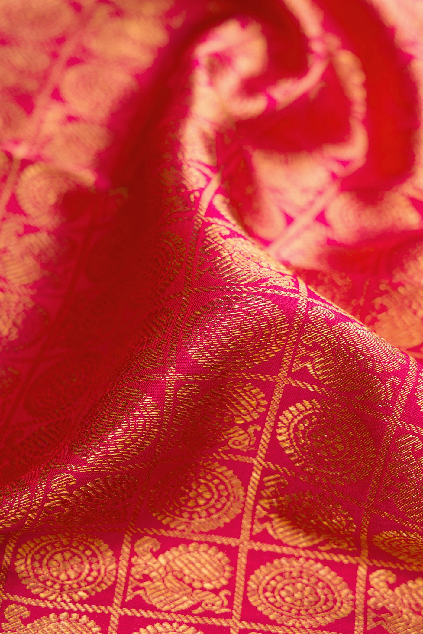 Close up of Pink Dual Tone Kanchipuram Silk Saree with Zari Brocade on the body and Zari And Thread Border.  displaying folds