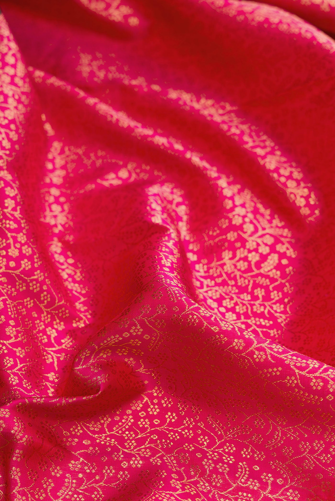 Close up of Dark Pink Dual Tone Kanchipuram Silk Saree with Zari Brocade on the body and Zari Border.  displaying folds