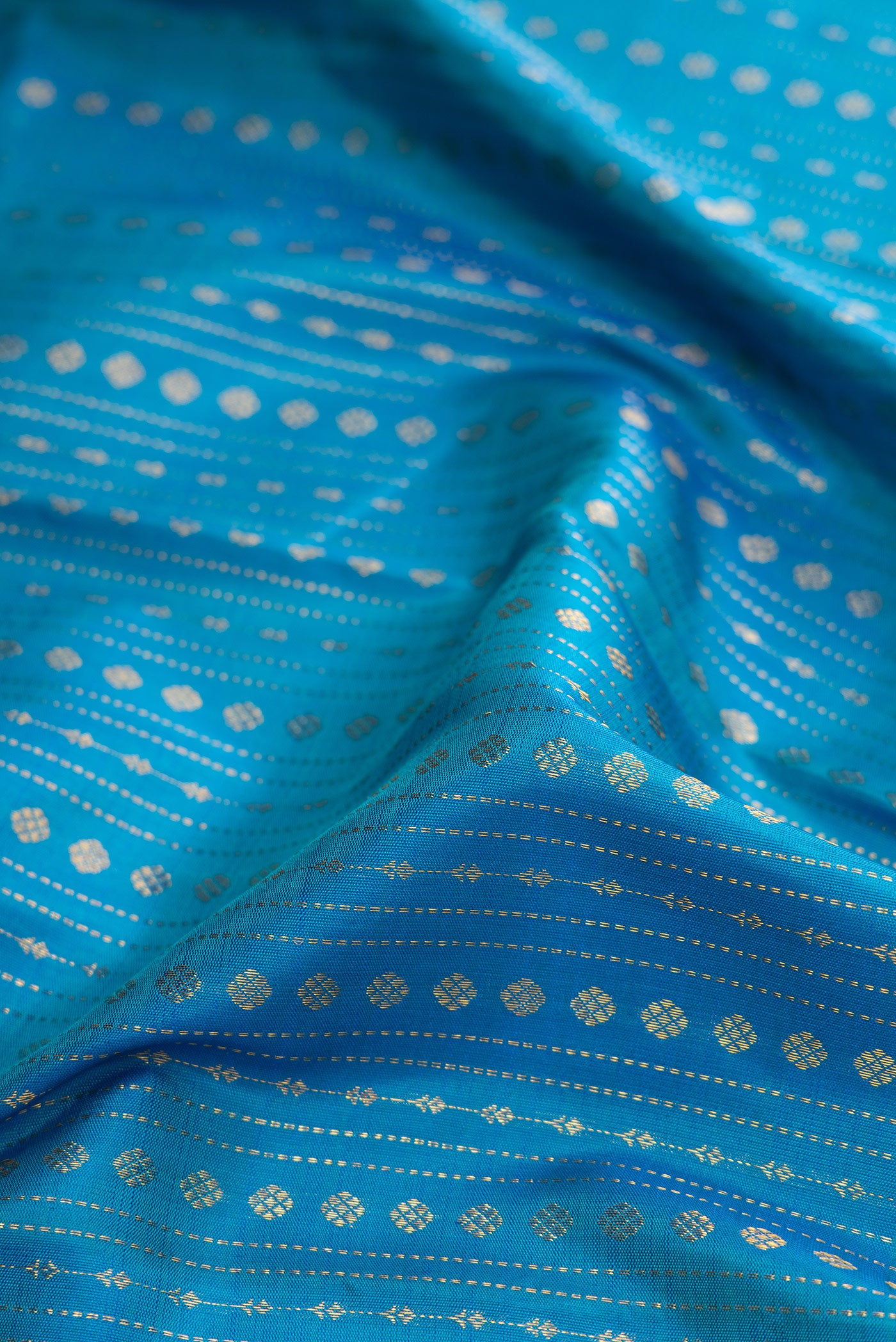 Close up of Peacock Blue Dual Tone Kanchipuram Silk Saree with Stripes on the body and Zari Border.  displaying folds