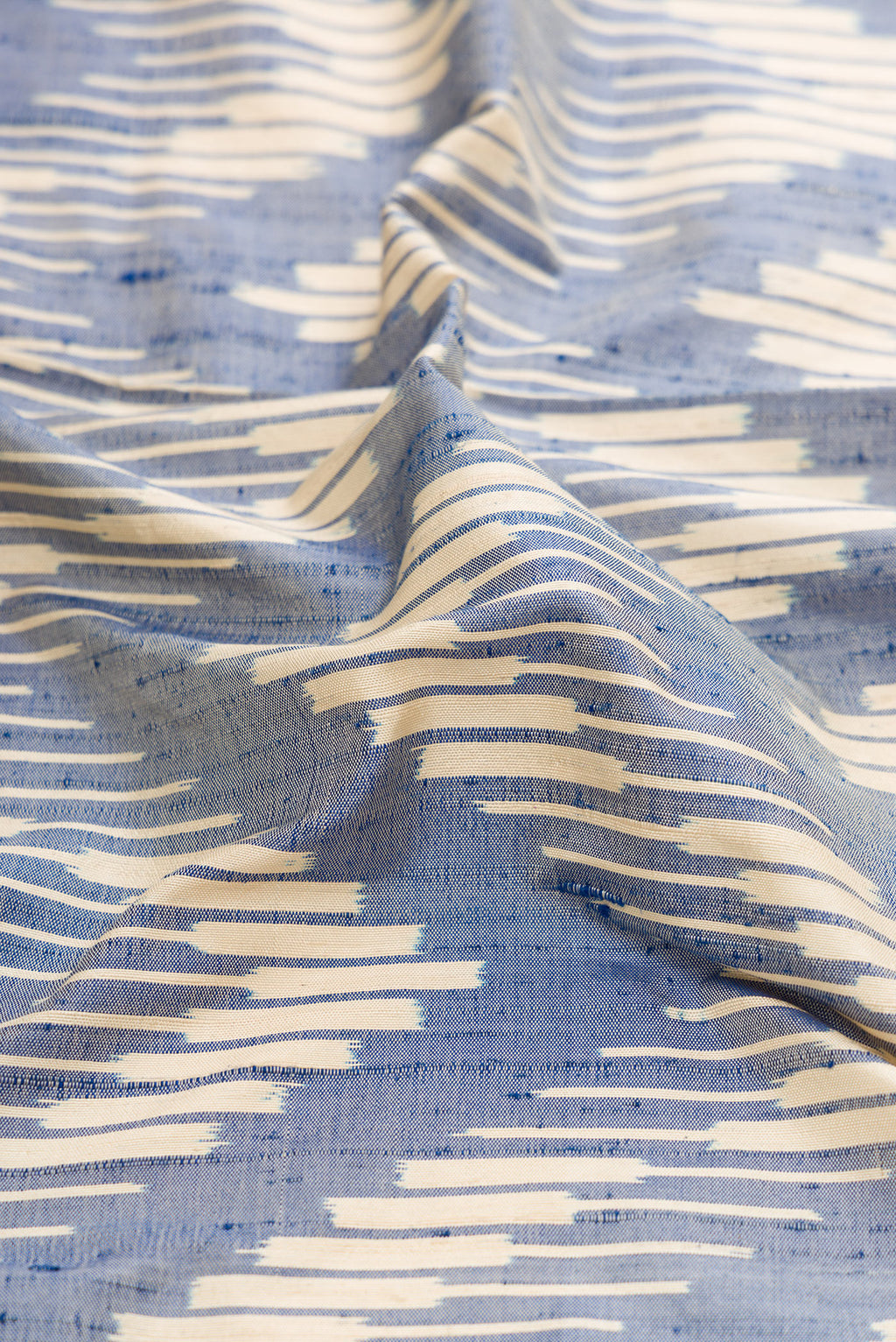 Close up of Grey Dual Tone Double Ikat Saree with Ikat Print on the body and Zari Border.  displaying folds