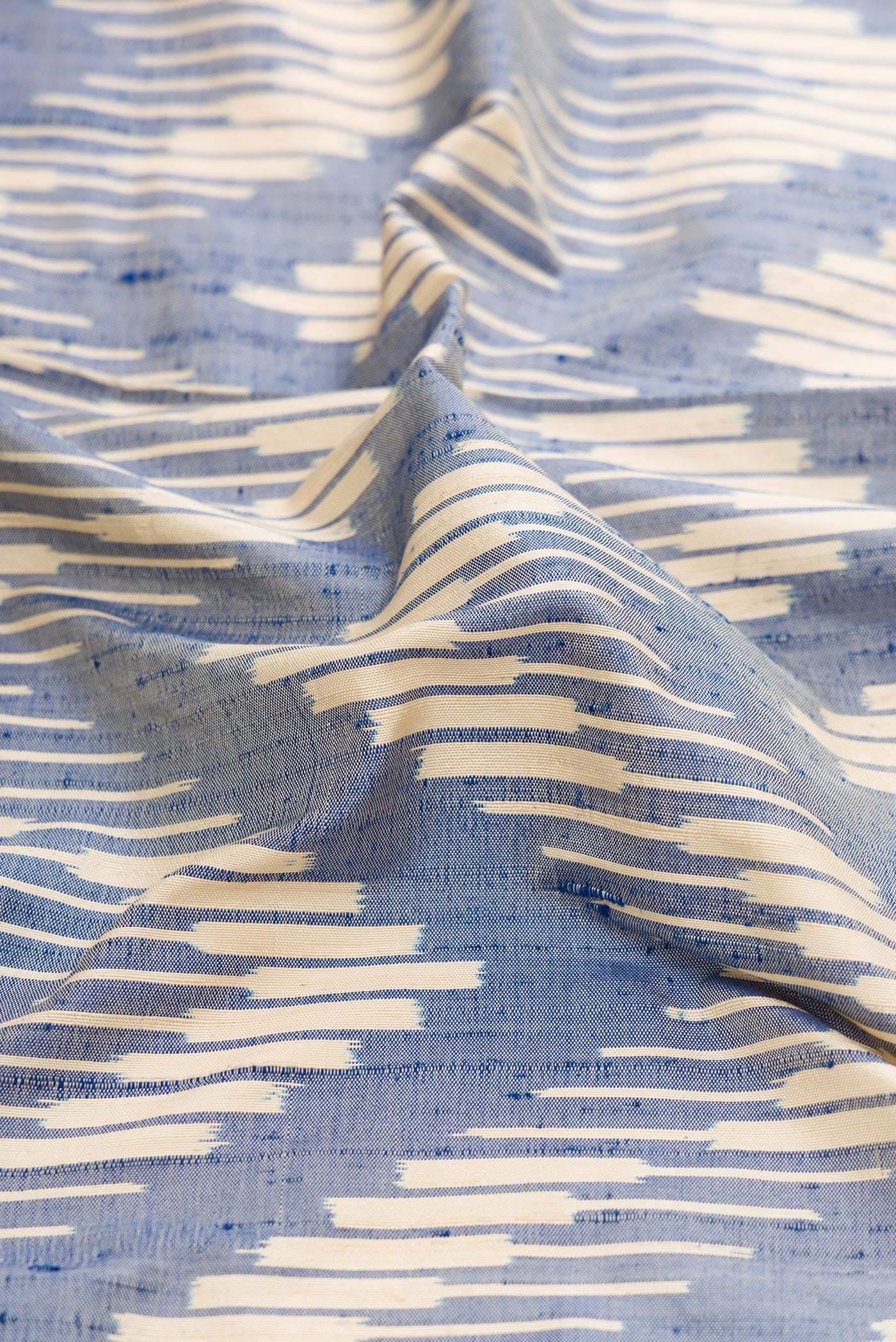Close up of Grey Dual Tone Double Ikat Saree with Ikat Print on the body and Zari Border.  displaying folds