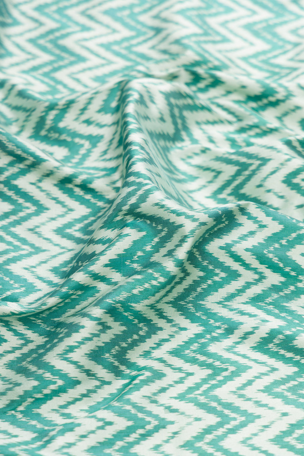 Close up of Blue Dual Tone Double Ikat Saree with Ikat Print on the body and Zari Border.  displaying folds