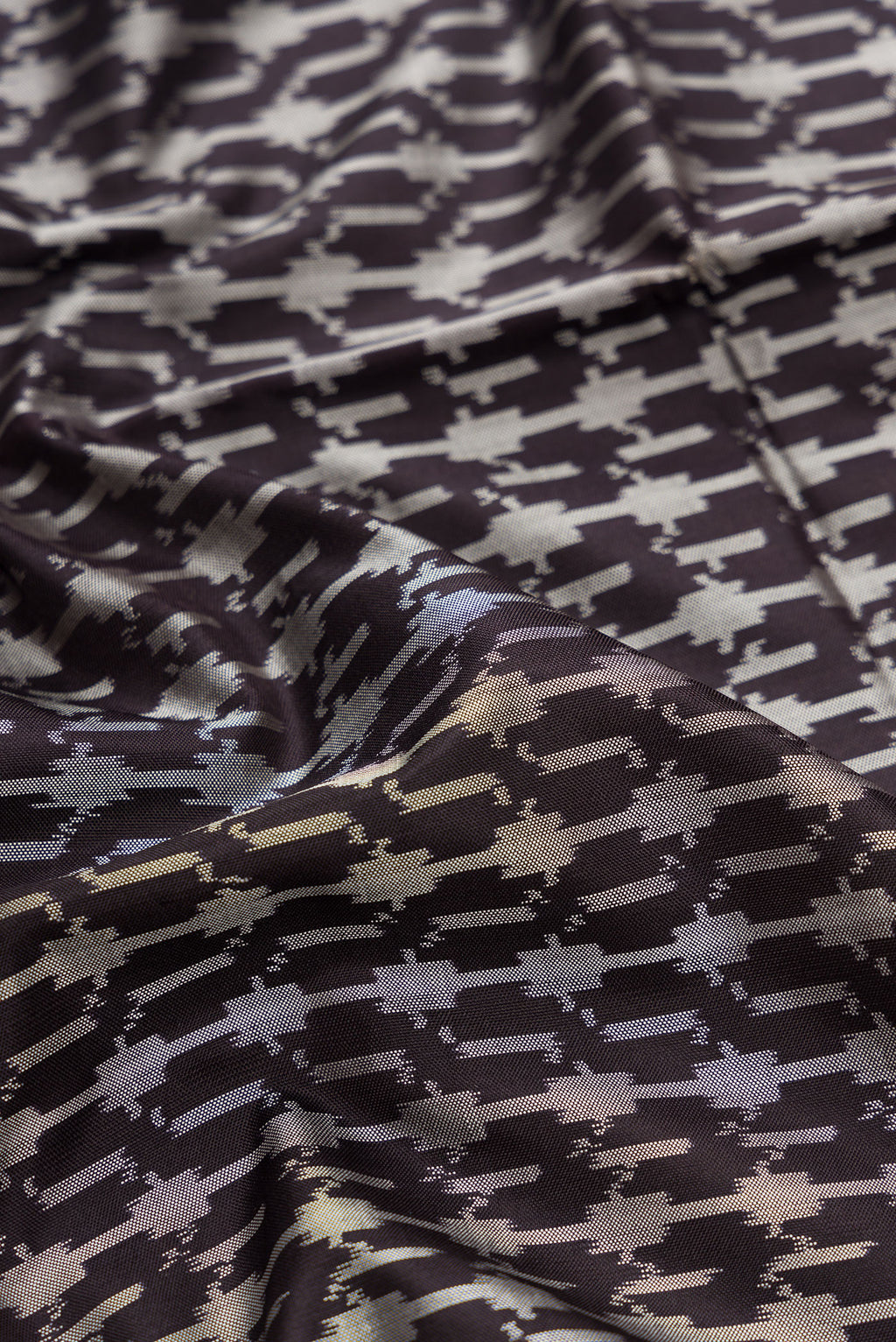 Close up of Black Dual Tone Double Ikat Saree with Ikat Print on the body and Zari Border.  displaying folds