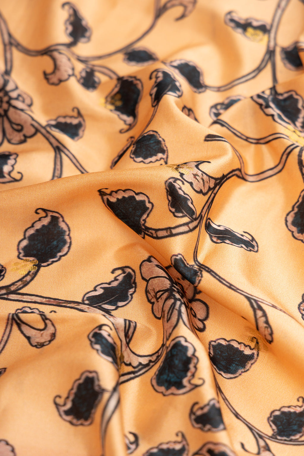Close up of Peach Dual Tone Paithani Silk Saree with Printed design on the body and Zari Border.  displaying folds