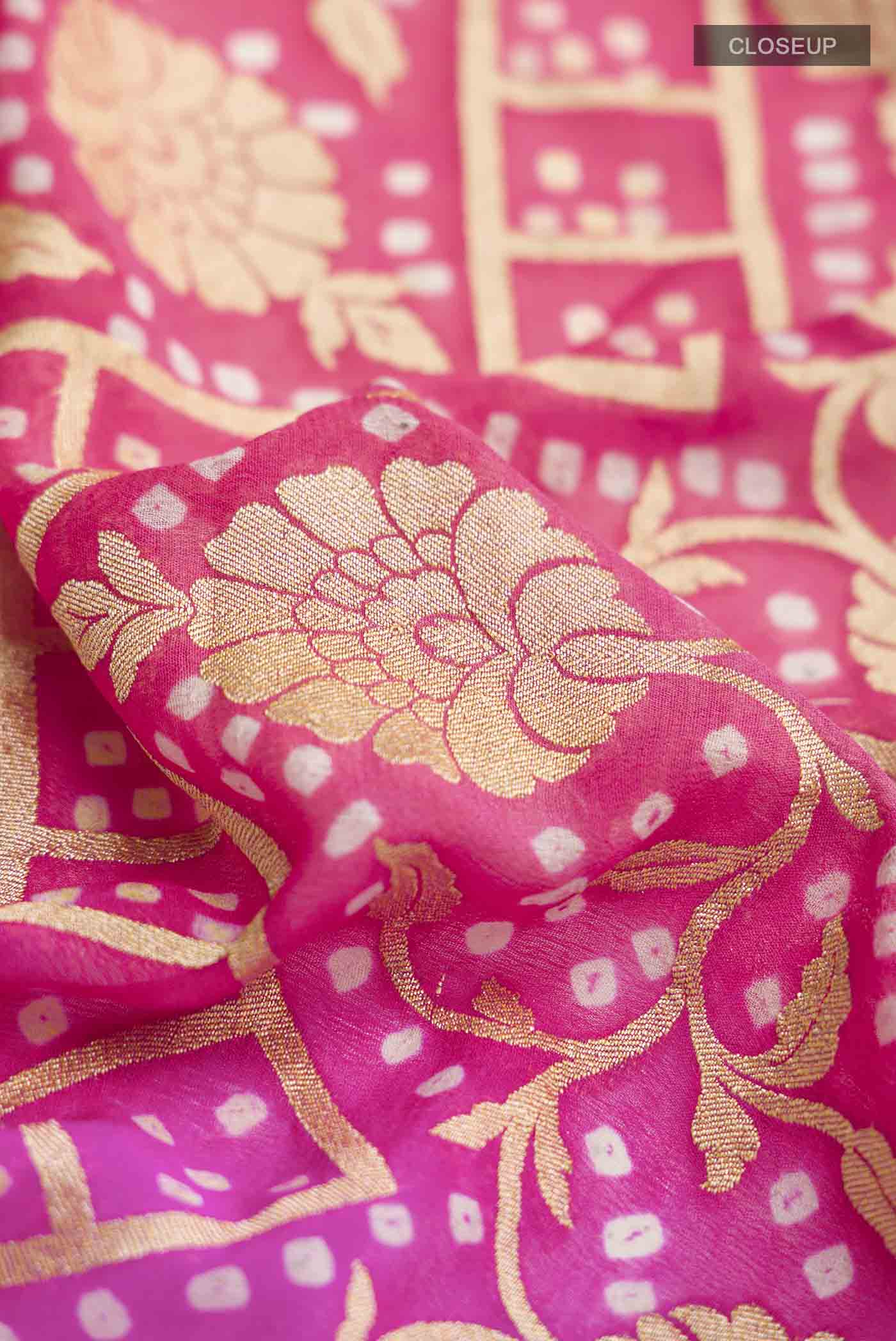 Close up of Rani Pink Banarasi Georgette Saree with Zari Butta on the body and Zari Border displaying folds