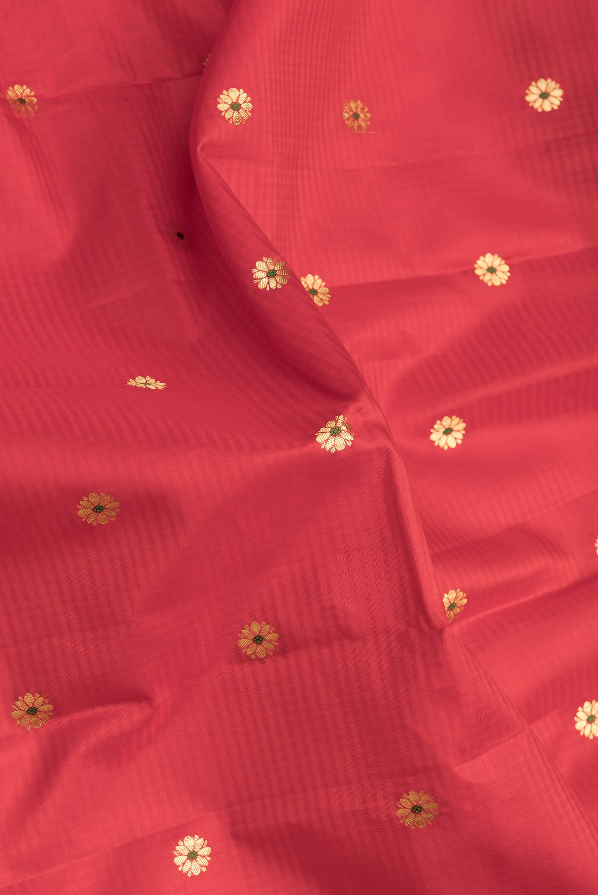 Close up of Red Dual Tone Kanchipuram Silk Saree with Zari And Thread Butta on the body and Zari Border.  displaying folds