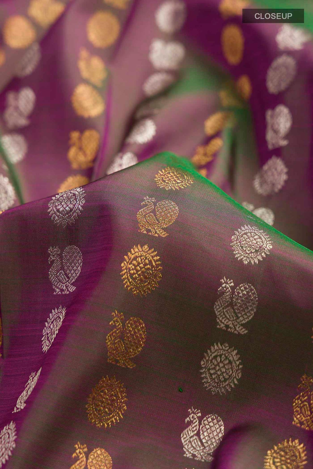 Close up of Green with Pink Color Kanchipuram Silk Saree with Zari Butta on the body and Zari Border displaying folds