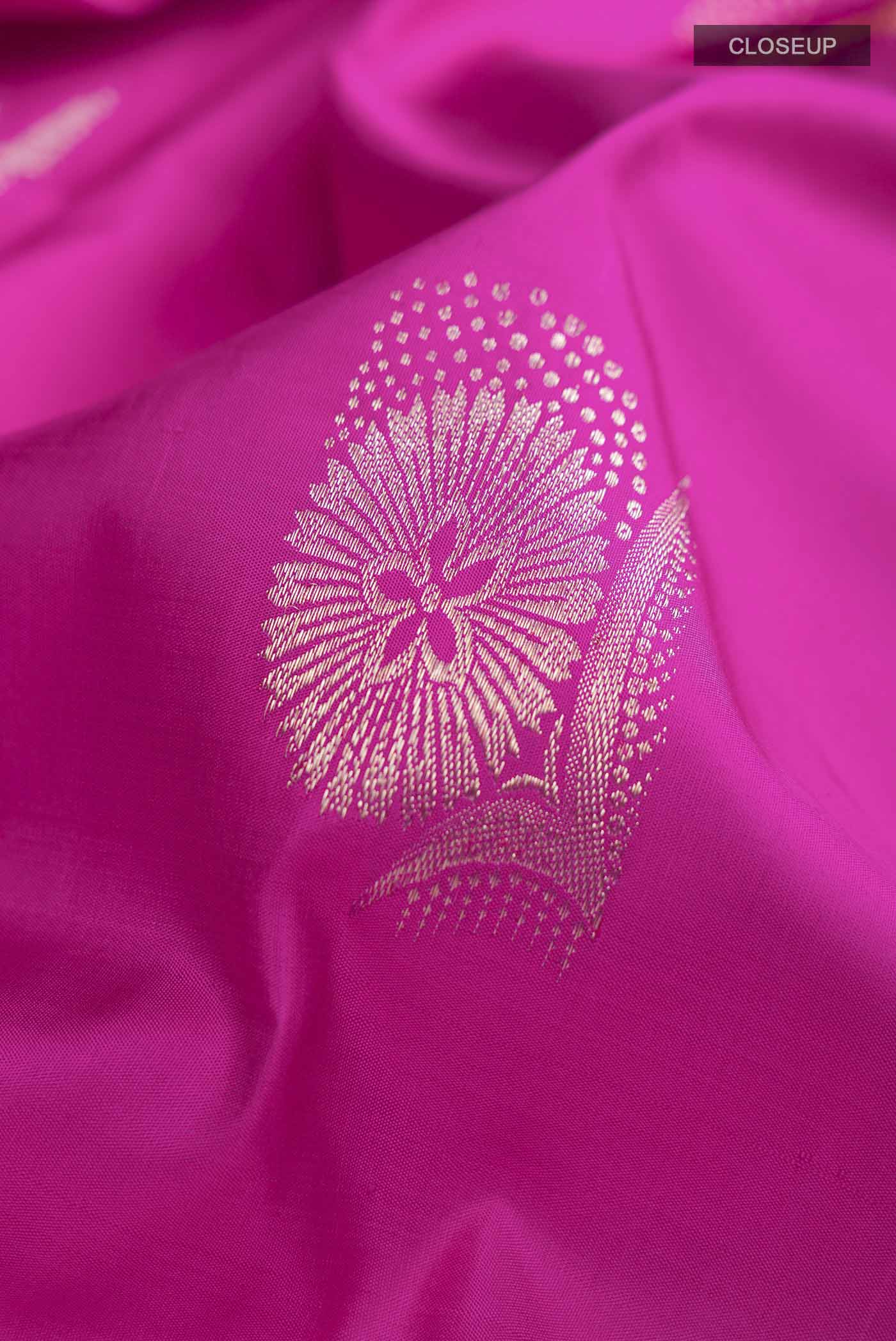 Close up of Pink Kanchipuram Silk Saree with Zari Butta on the body and Zari Border displaying folds