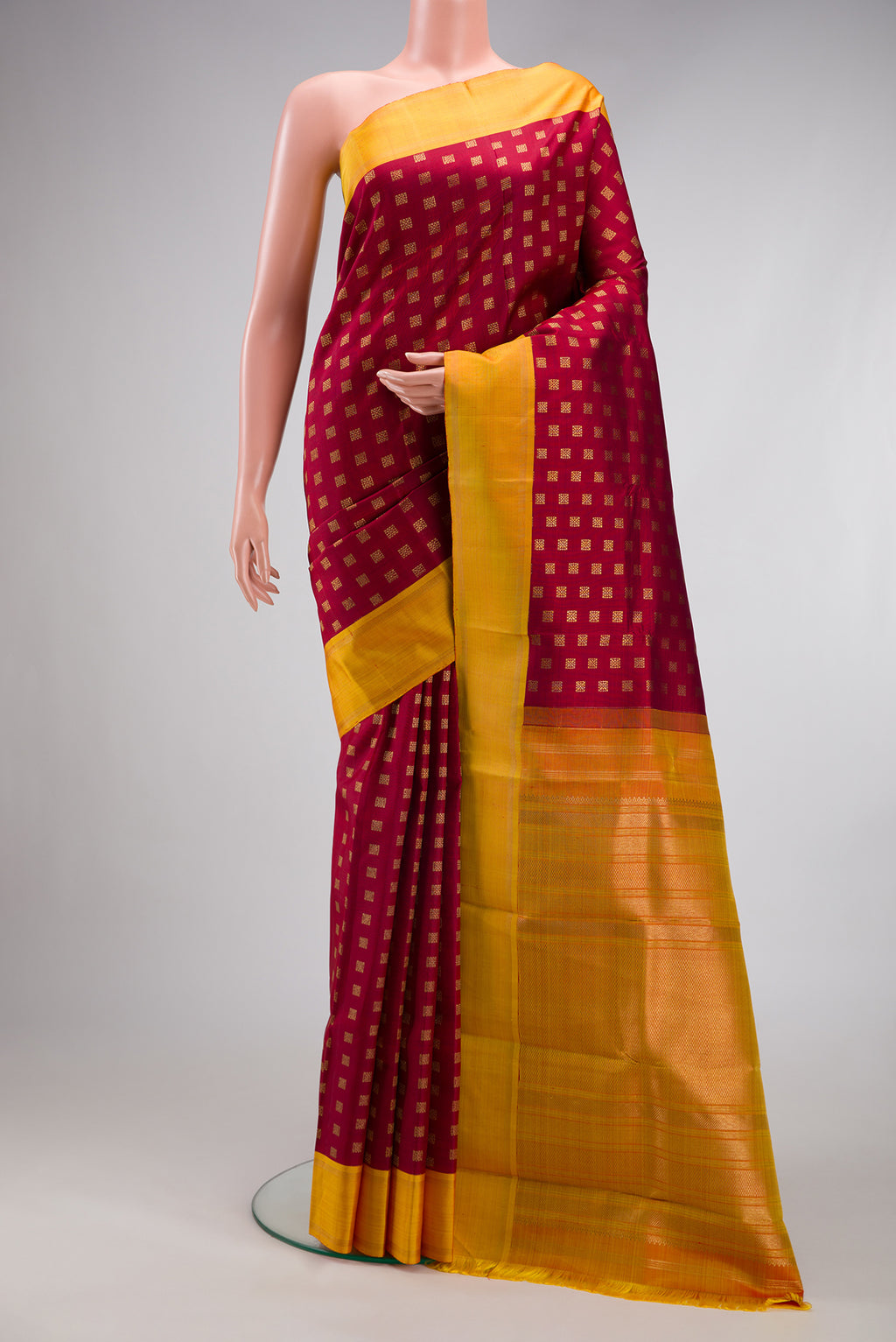 Pure Silk Pure Zari Maroon Kanchipuram Saree with Zari Butta on the body and Plain Border.  displayed on a mannequin