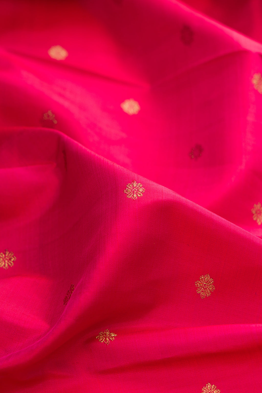 Close up of Pure Silk Pure Zari Dark Pink Dual Tone Kanchipuram Saree with Zari Butta on the body and Zari Border.  displaying folds