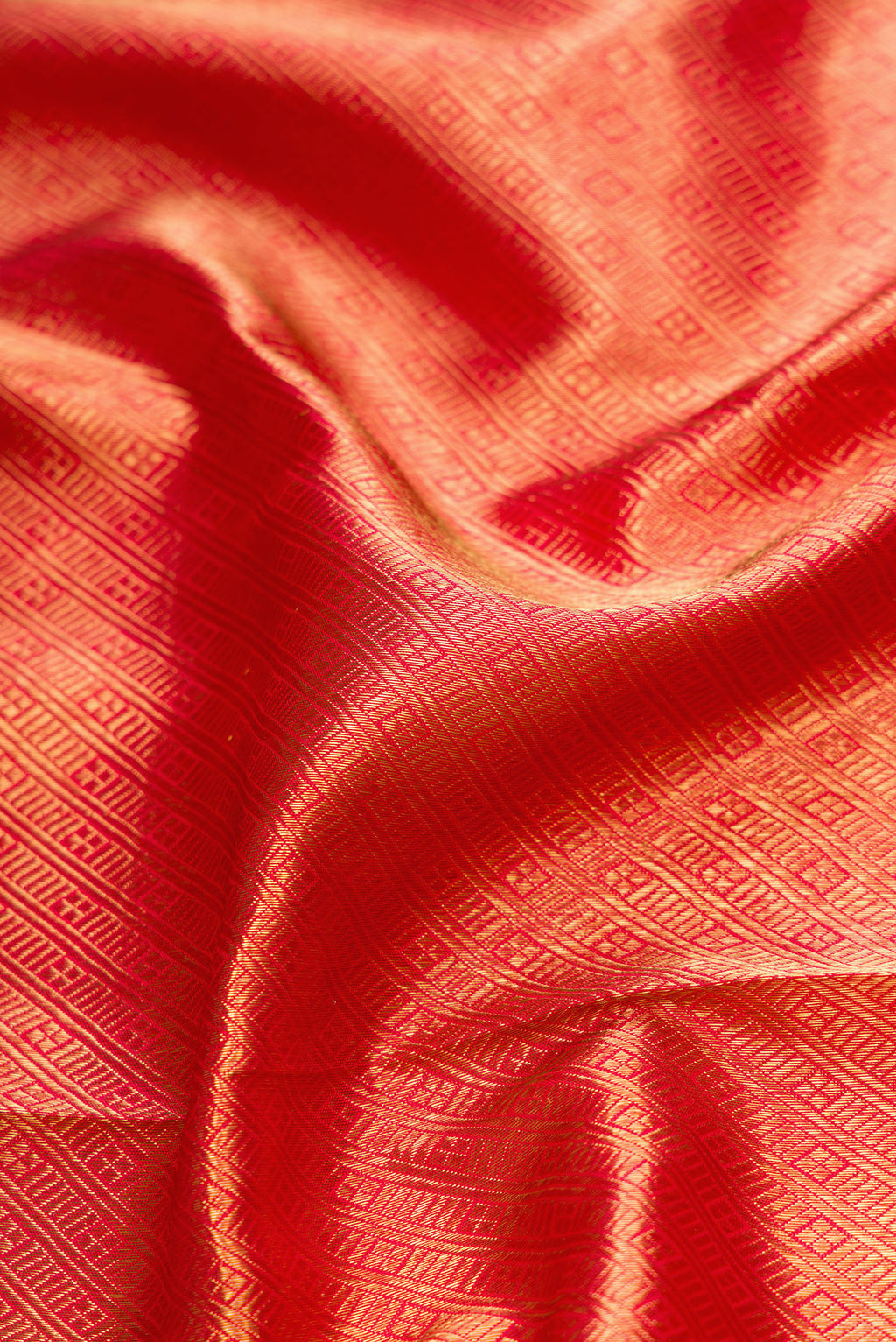 Close up of Pure Silk Pure Zari Red Dual Tone Kanjivaram Saree with Zari Brocade on the body and Zari Border.  displaying folds