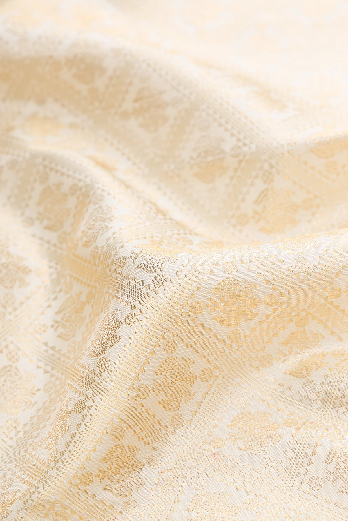 Close up of Pure Silk Pure Zari Off White Dual Tone Kanjivaram Saree with Zari Brocade on the body and Zari Border.  displaying folds