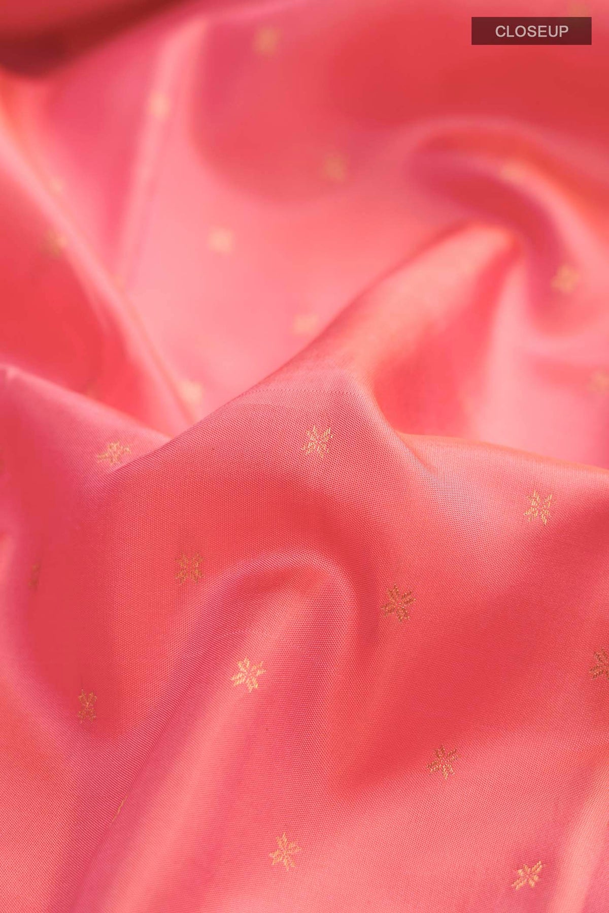 Close up of Pink Kanchipuram Silk Saree with Zari Butta on the body and Zari Border displaying folds