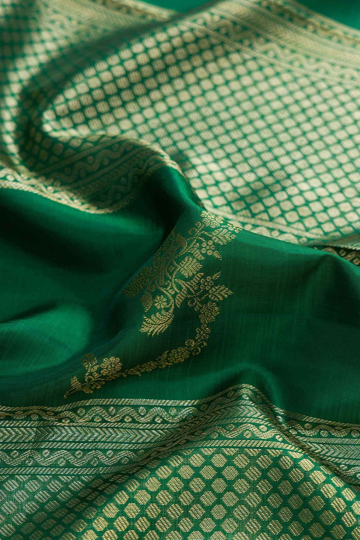 Close up of Green Kanchipuram Silk Saree with Stripes on the body and Zari Border displaying folds