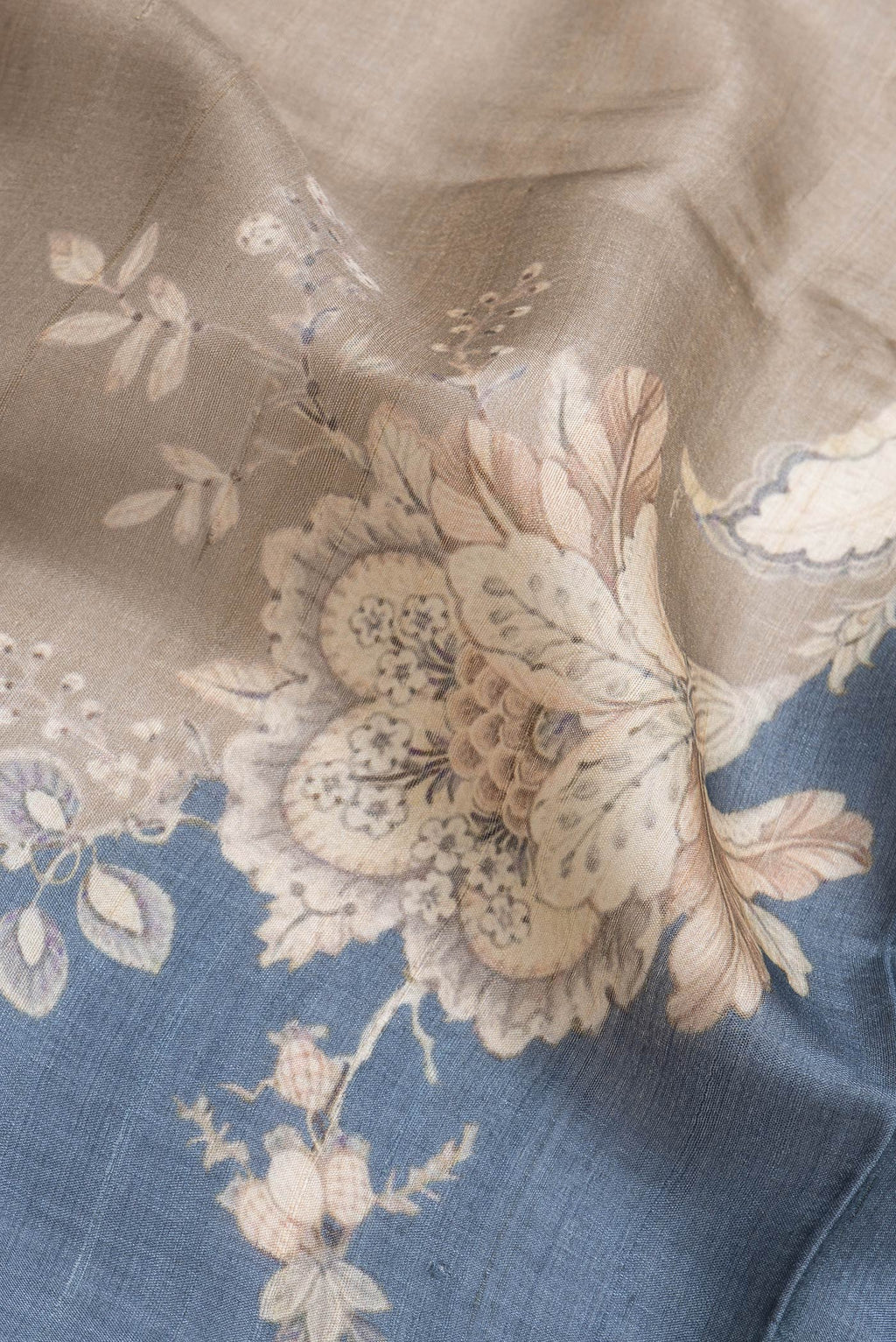 Close up of Grey Dual Tone Tussar Silk Saree with Printed design on the body and Zari Border.  displaying folds