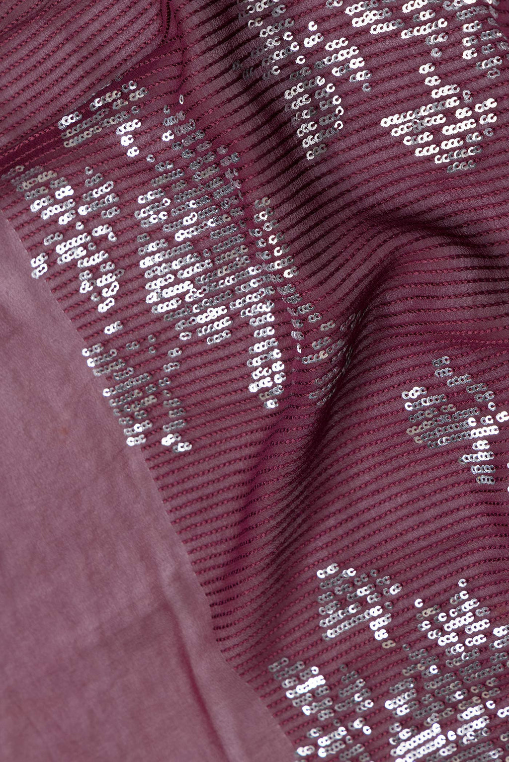 Close up of Maroon Dual Tone Georgette Saree with Embroidery on the body and Without Border.  displaying folds