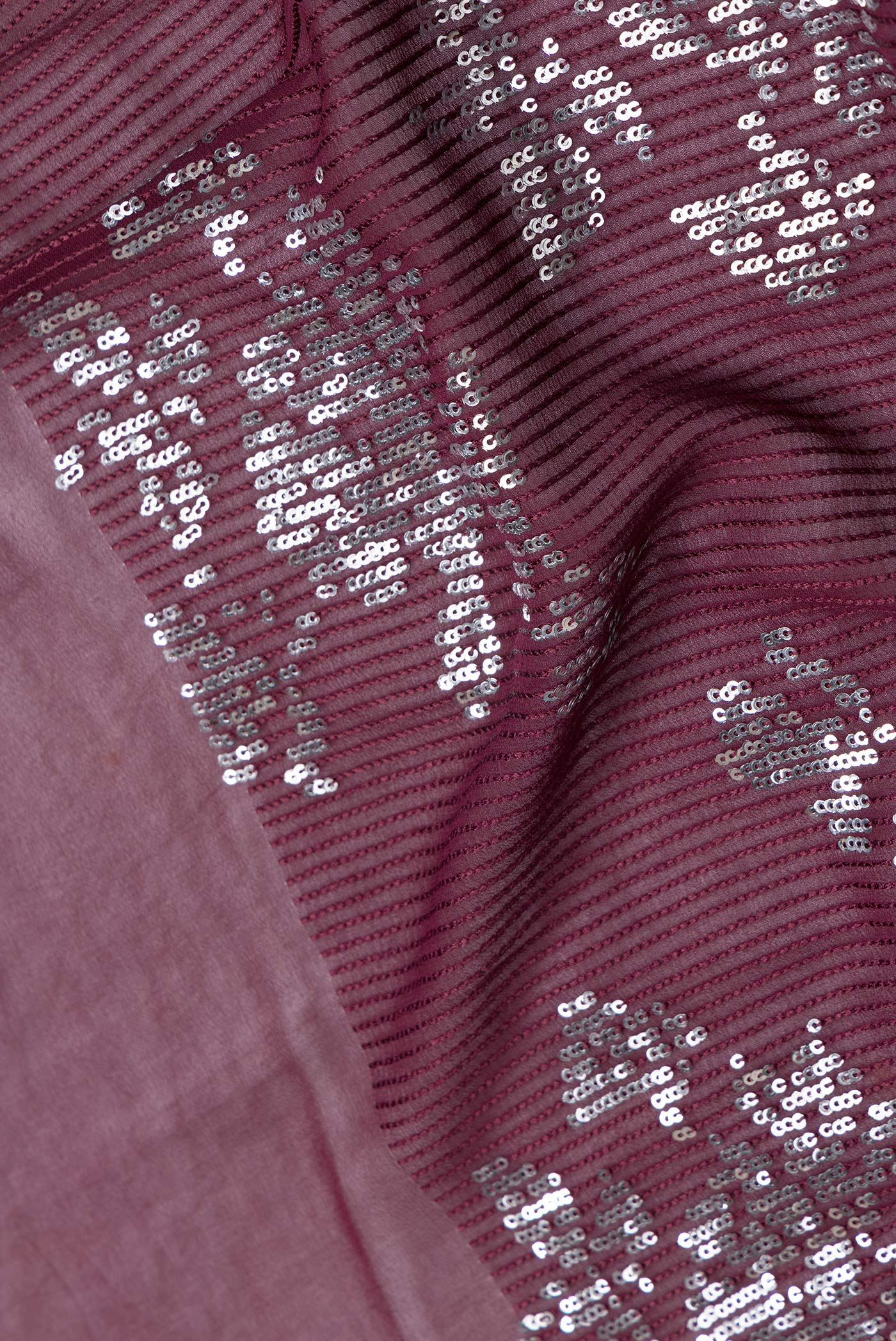 Close up of Maroon Dual Tone Georgette Saree with Embroidery on the body and Without Border.  displaying folds