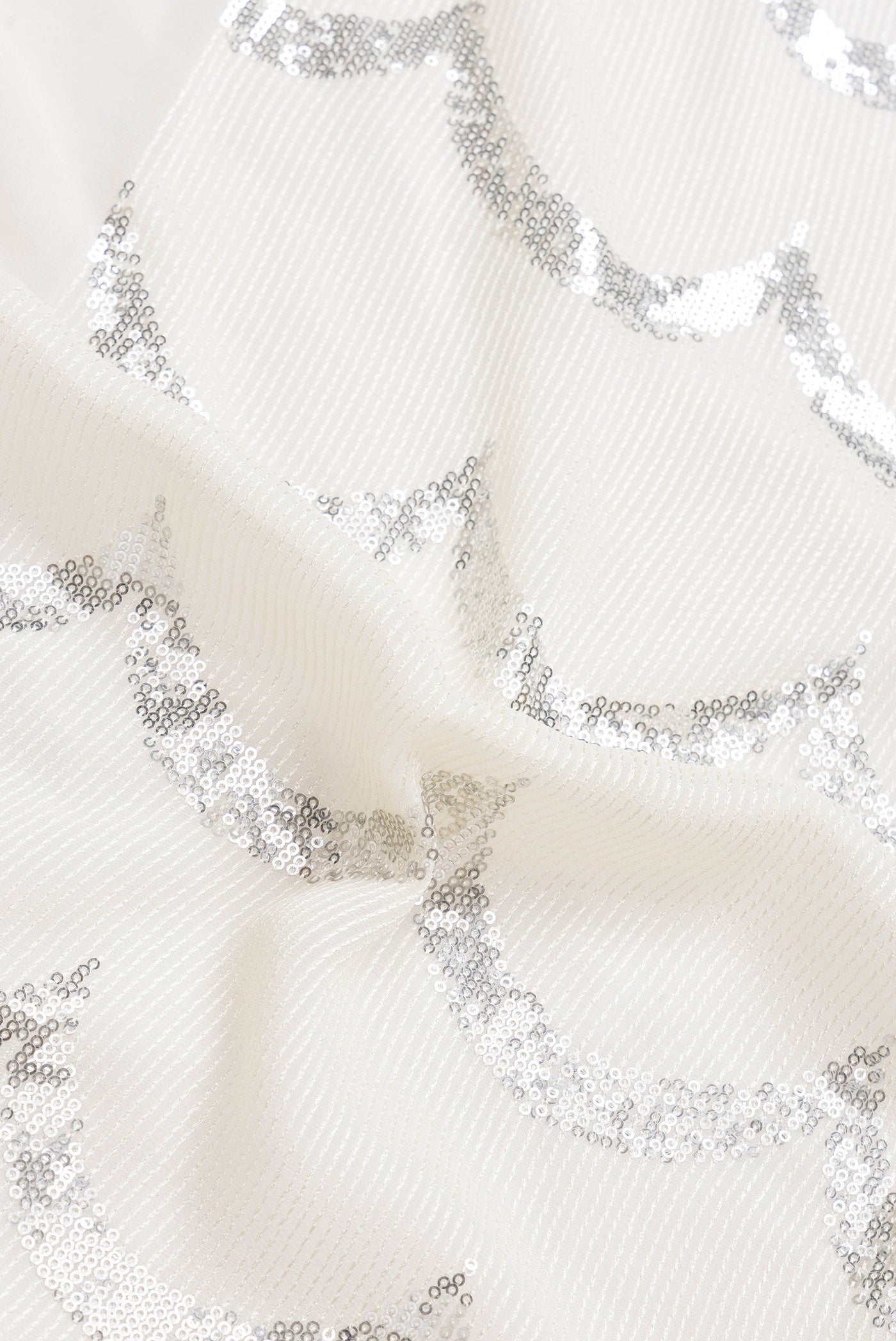 Close up of Beige Dual Tone Mysore Georgette Saree with Embroidery on the body and Without Border.  displaying folds