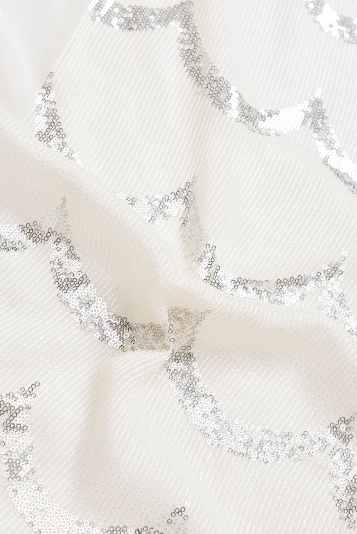 Close up of Beige Dual Tone Mysore Georgette Saree with Embroidery on the body and Without Border.  displaying folds
