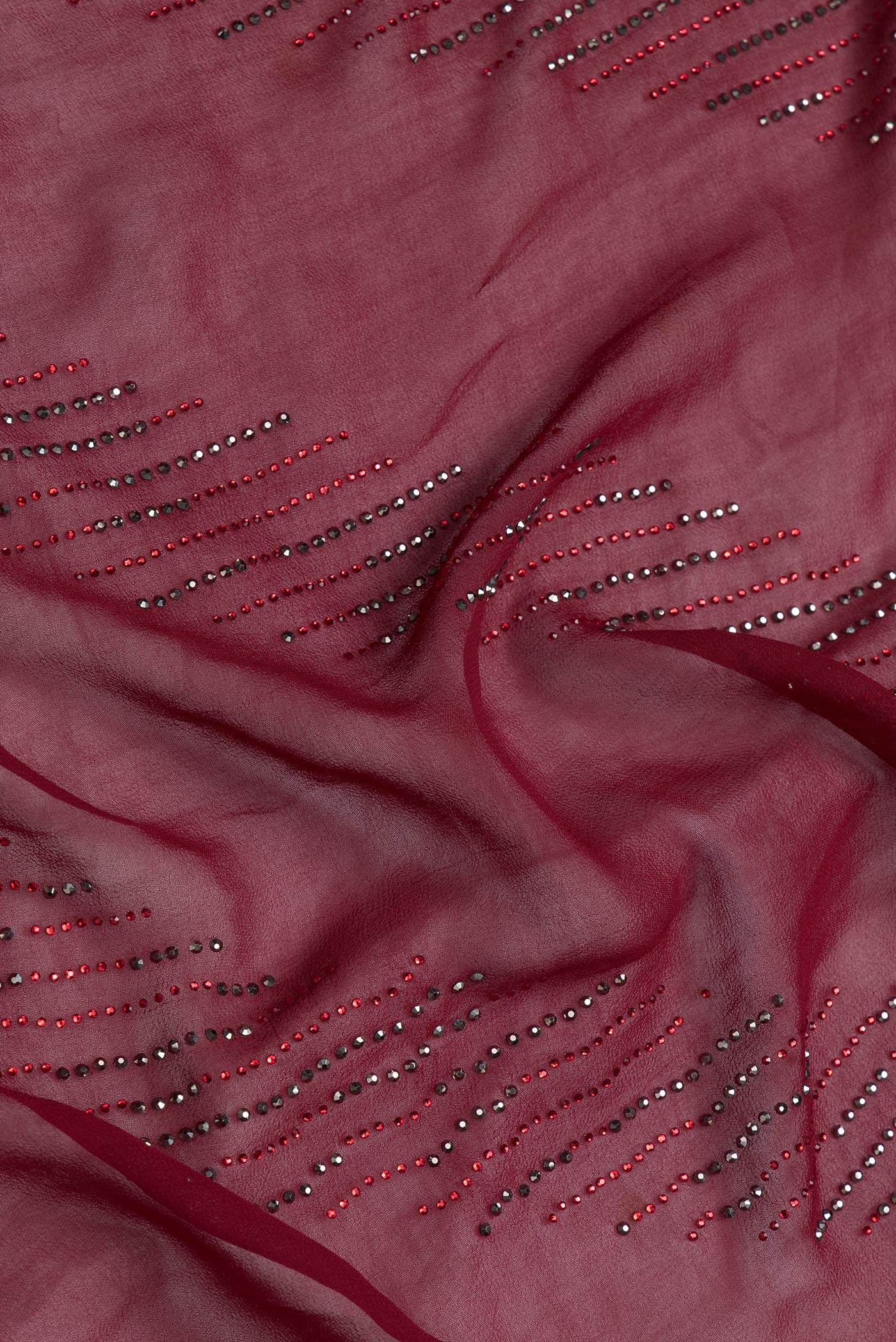 Close up of Maroon Dual Tone Georgette Saree with Embroidery on the body and Embroidery Border.  displaying folds