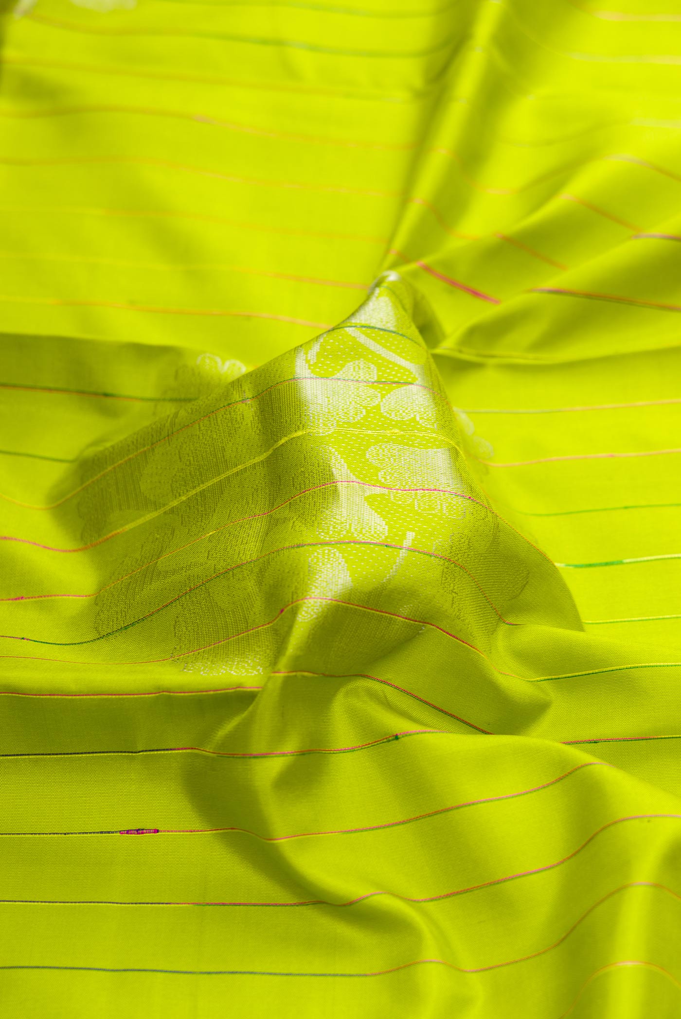 Close up of Parrot Green Dual Tone Kanchipuram Silk Saree with Stripes on the body and Without Border displaying folds