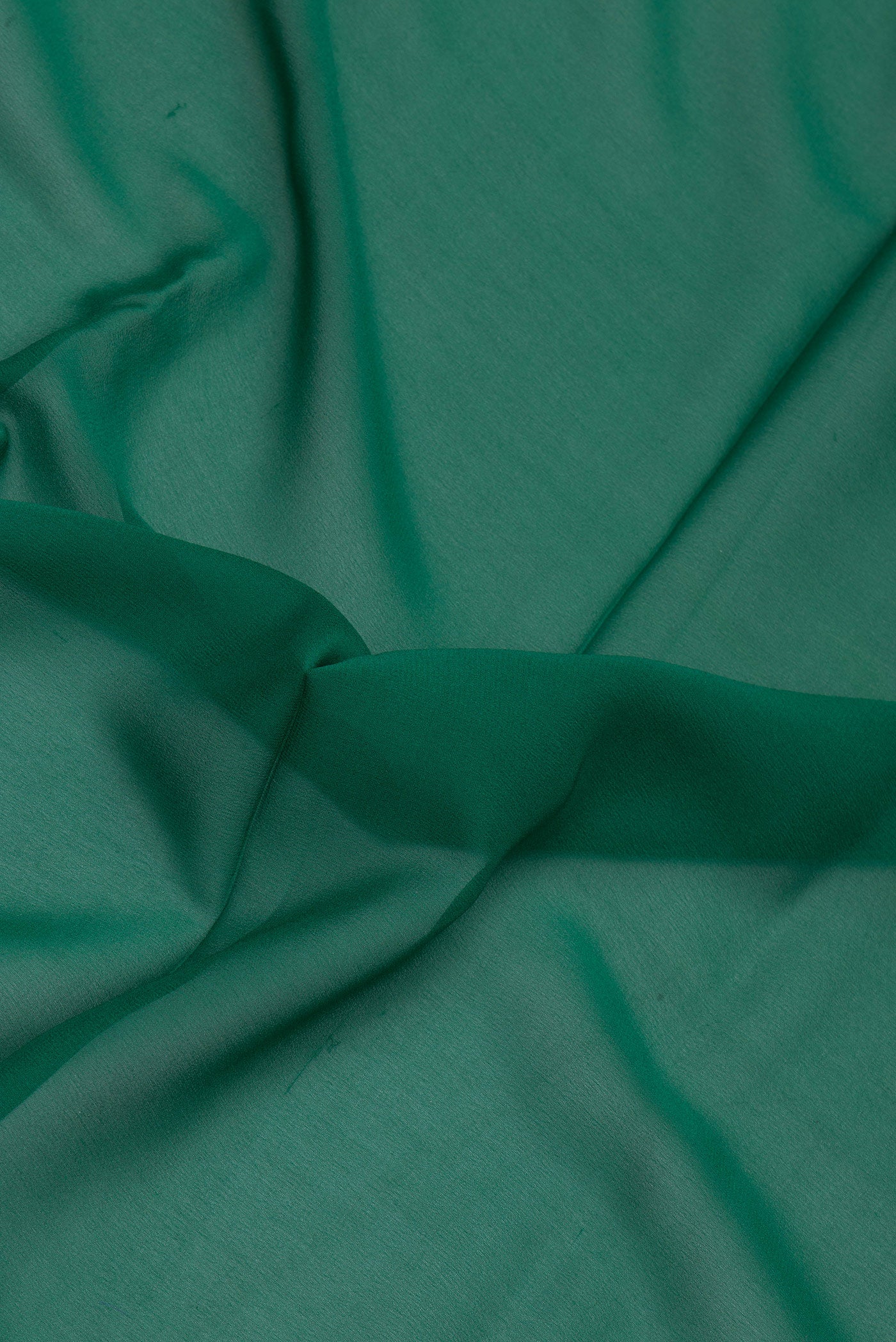 Close up of Green Mysore Georgette Saree with Plain Body and Zari Border.  displaying folds