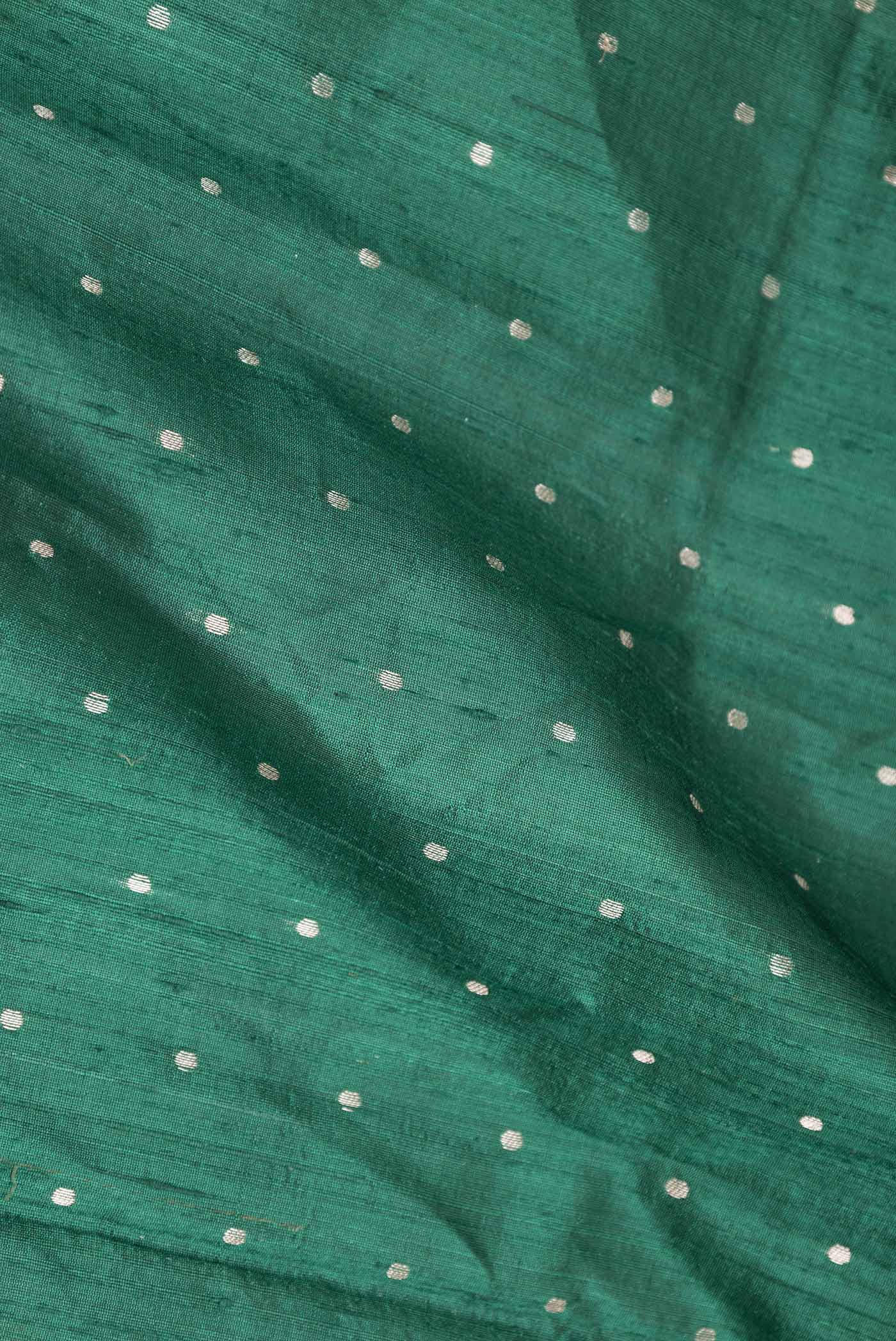 Close up of Green Dual Tone Raw Silk Saree with Zari Butta on the body and Zari Border displaying folds