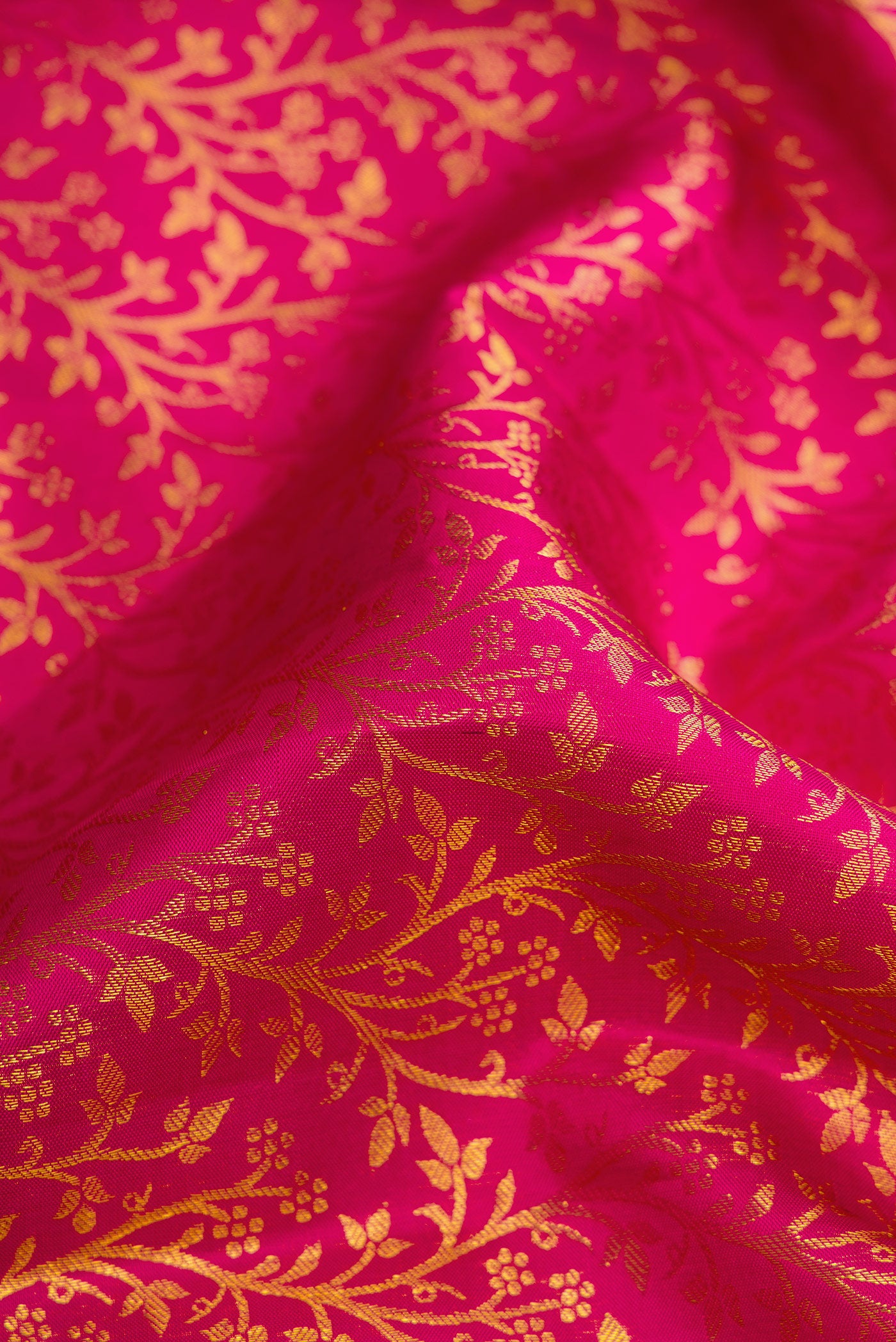 Close up of Magenta Dual Tone Kanchipuram Silk Saree with Zari Brocade on the body and Zari Border.  displaying folds