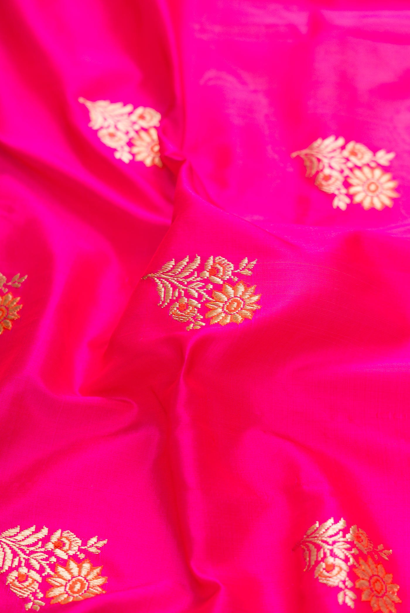 Close up of Pure Silk Pure Zari Pink Dual Tone Banarasi Saree with Zari And Thread Butta on the body and Zari Border displaying folds