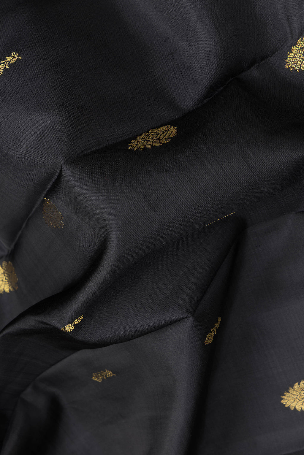 Close up of Black Dual Tone Kanjivaram Silk Saree with Zari Butta on the body and Zari Border.  displaying folds