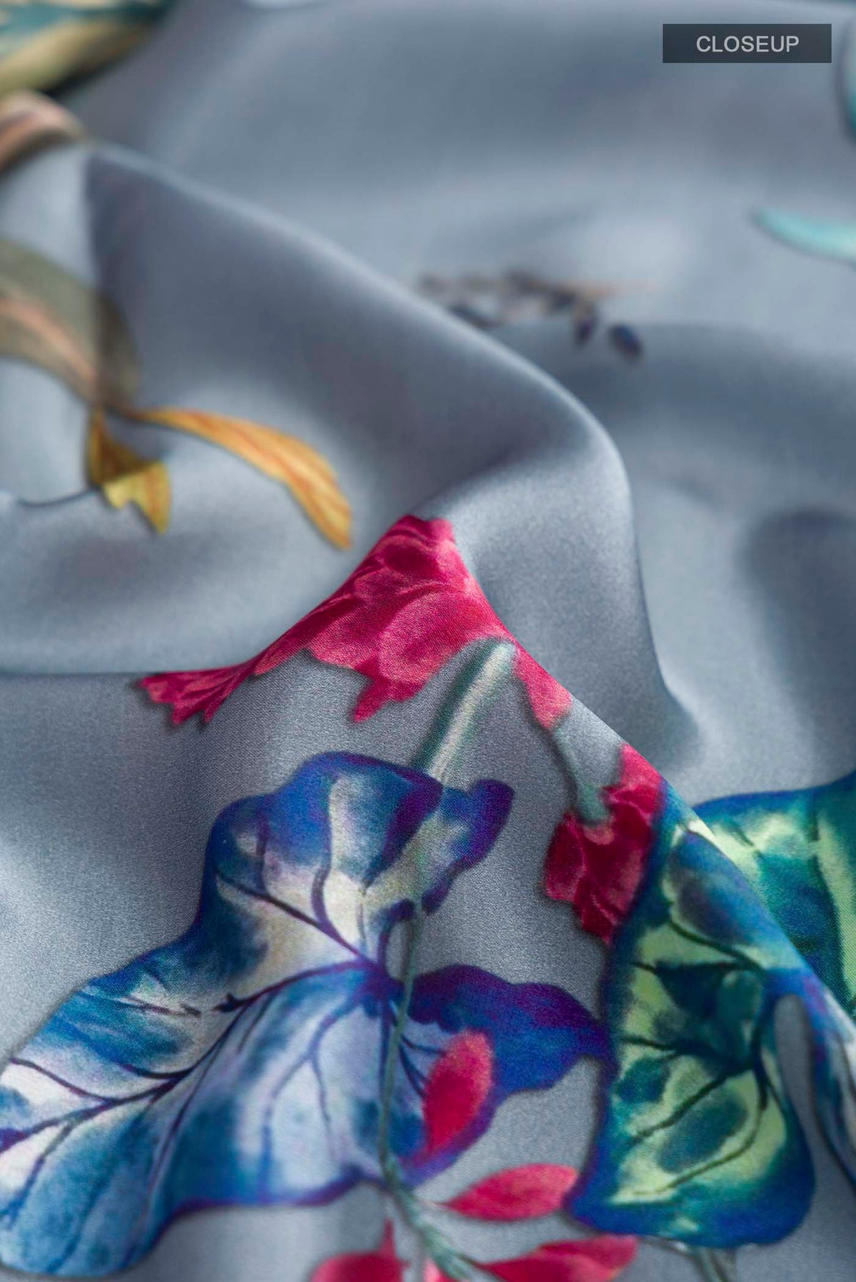 Close up of Blue Satin Silk Saree with Printed design on the body and Plain Border displaying folds