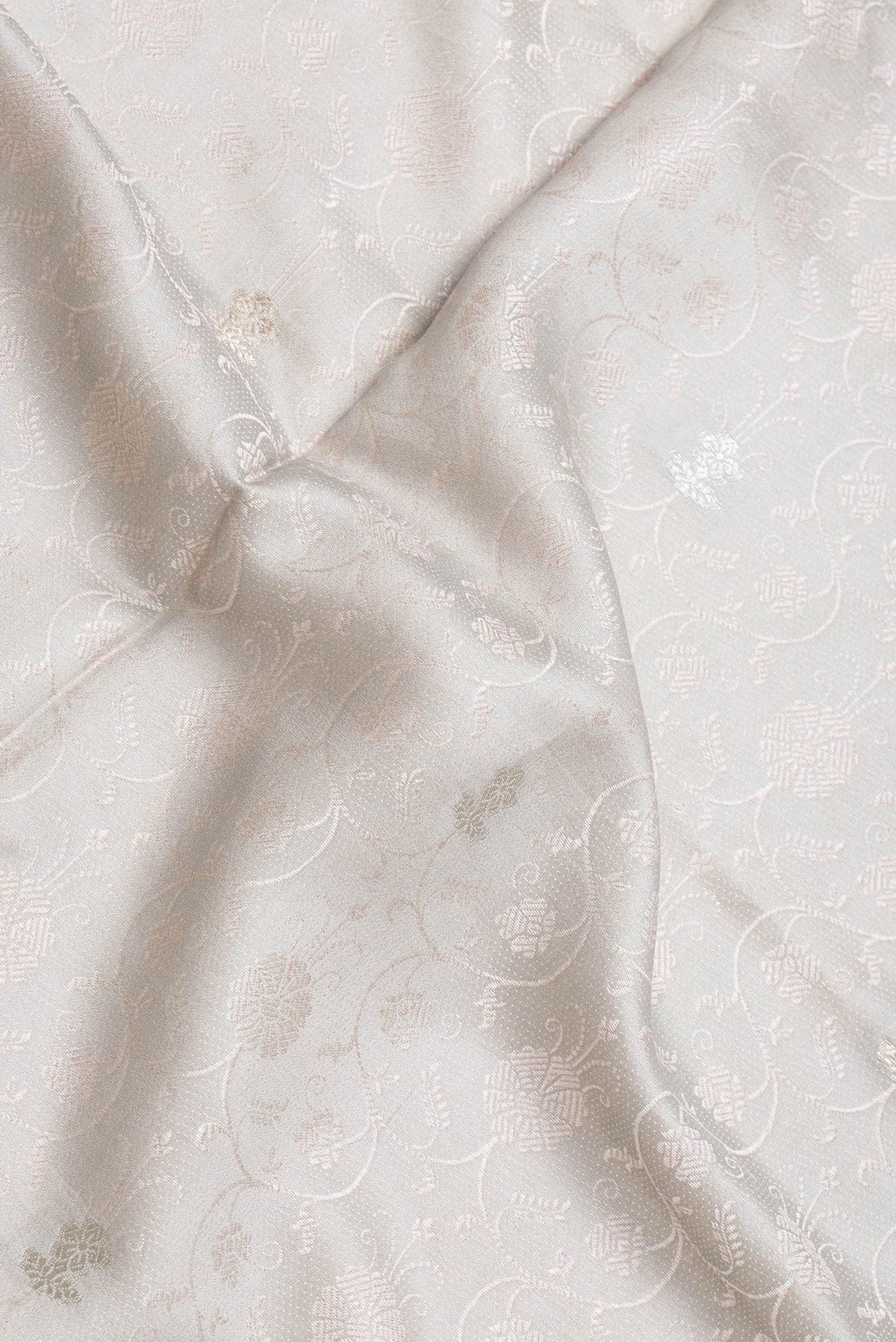 Close up of Grey Dual Tone Tussar Silk Saree with Jacquard design on the body and Thin Zari Line.  displaying folds