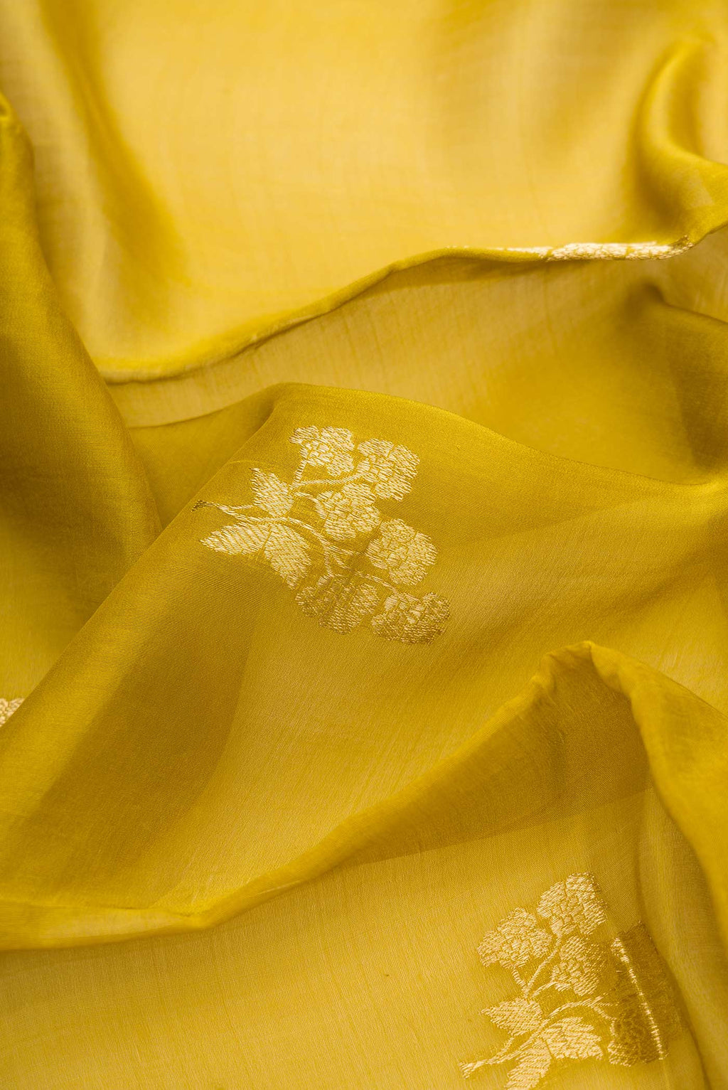 Close up of Mehandi Green Dual Tone Organza Silk Saree with Zari Butta on the body and Zari Border.  displaying folds