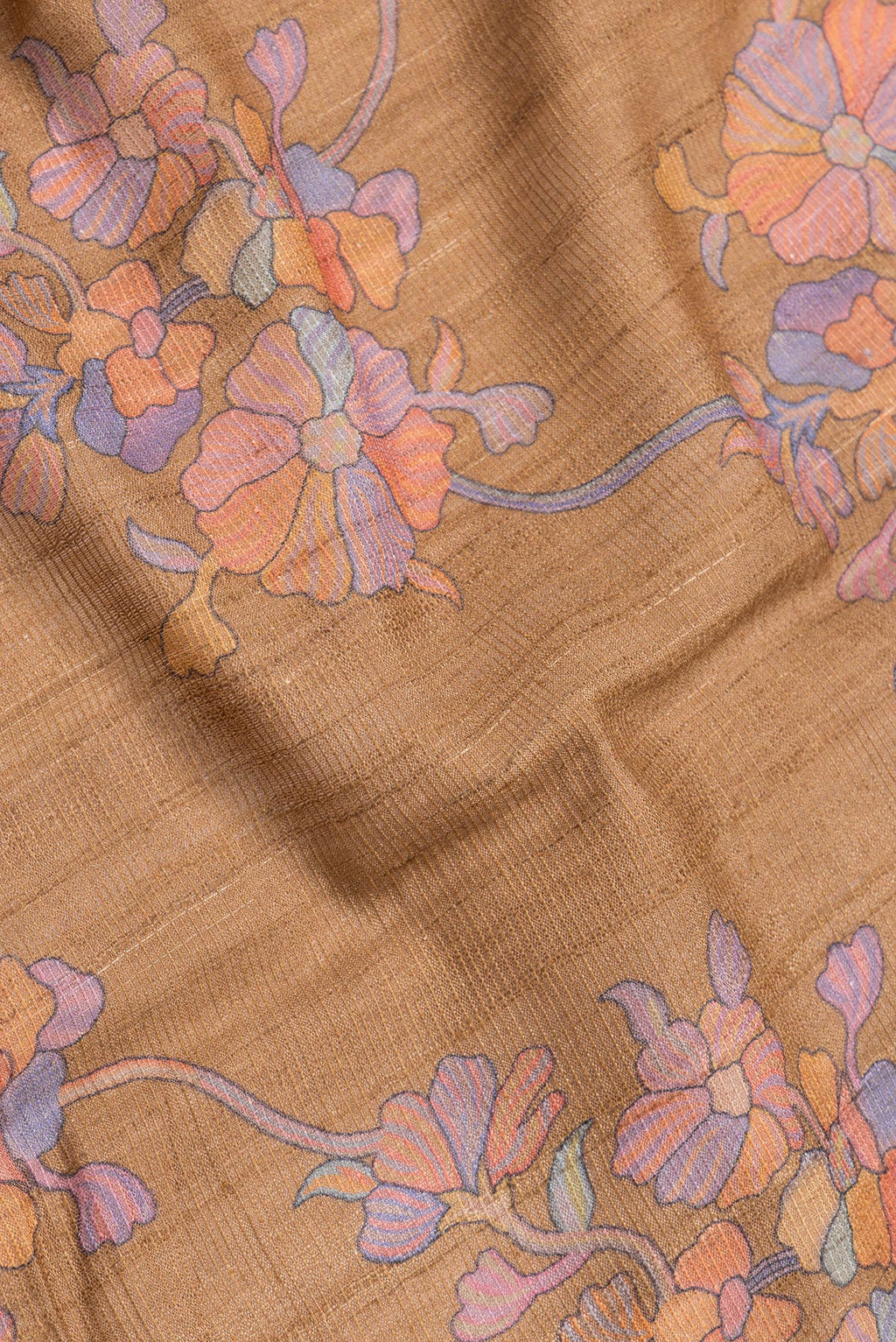 Close up of Brown Dual Tone Tussar Silk Saree with Printed design on the body and Zari Border.  displaying folds