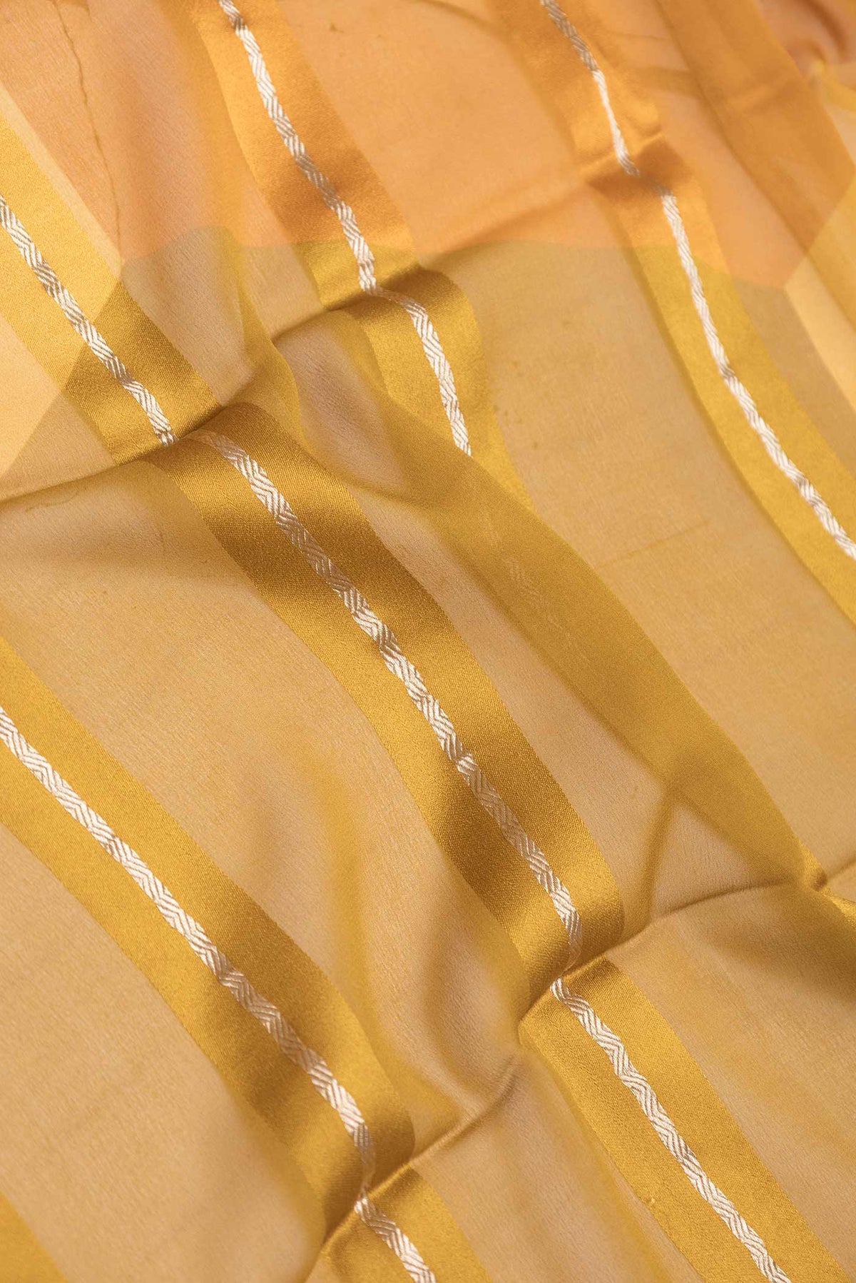 Close up of Mustard Dual Tone Mysore Georgette Saree with Stripes on the body and Zari Border displaying folds