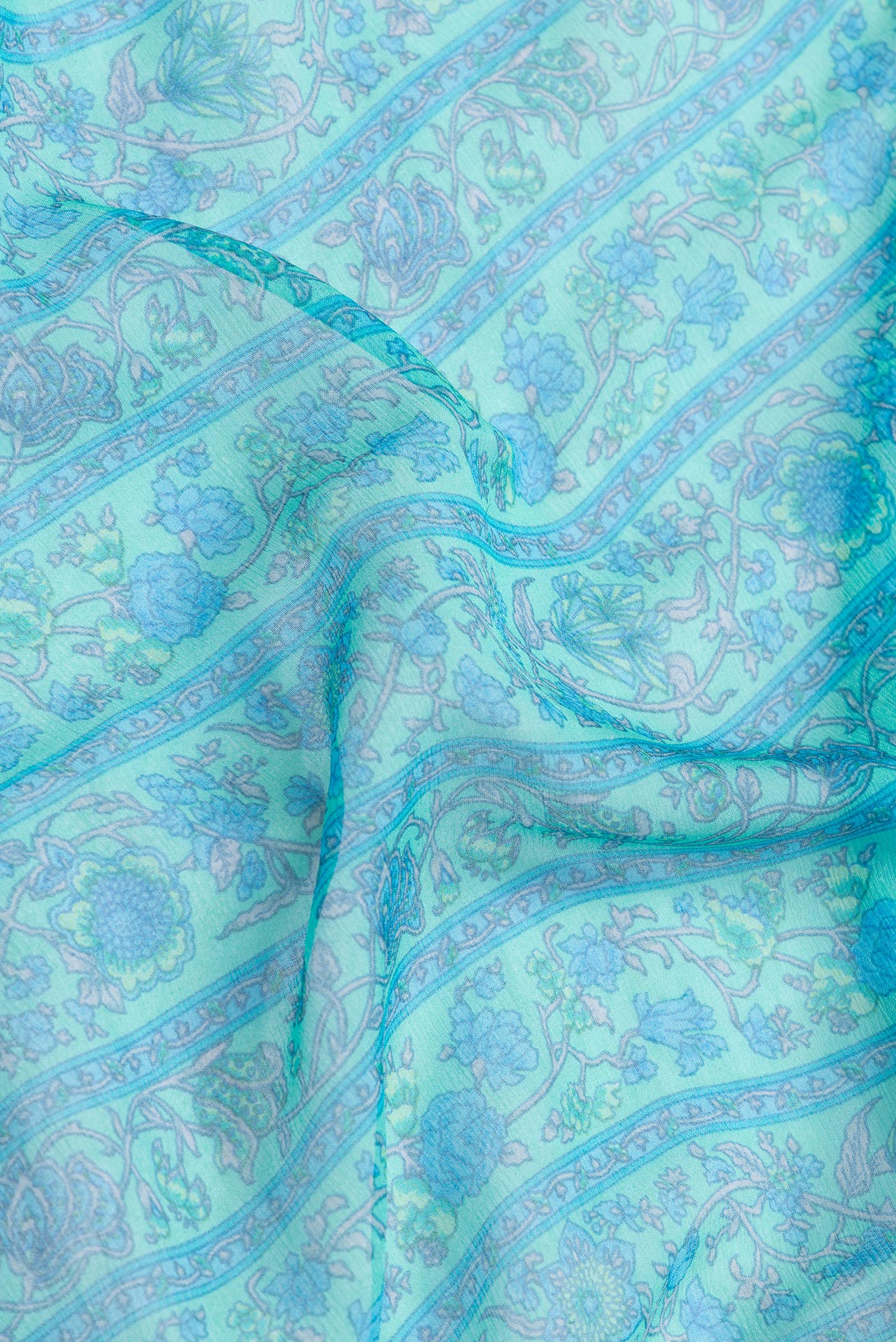 Close up of Sea Green Dual Tone Mysore Chiffon Saree with Printed design on the body and Zari Border.  displaying folds