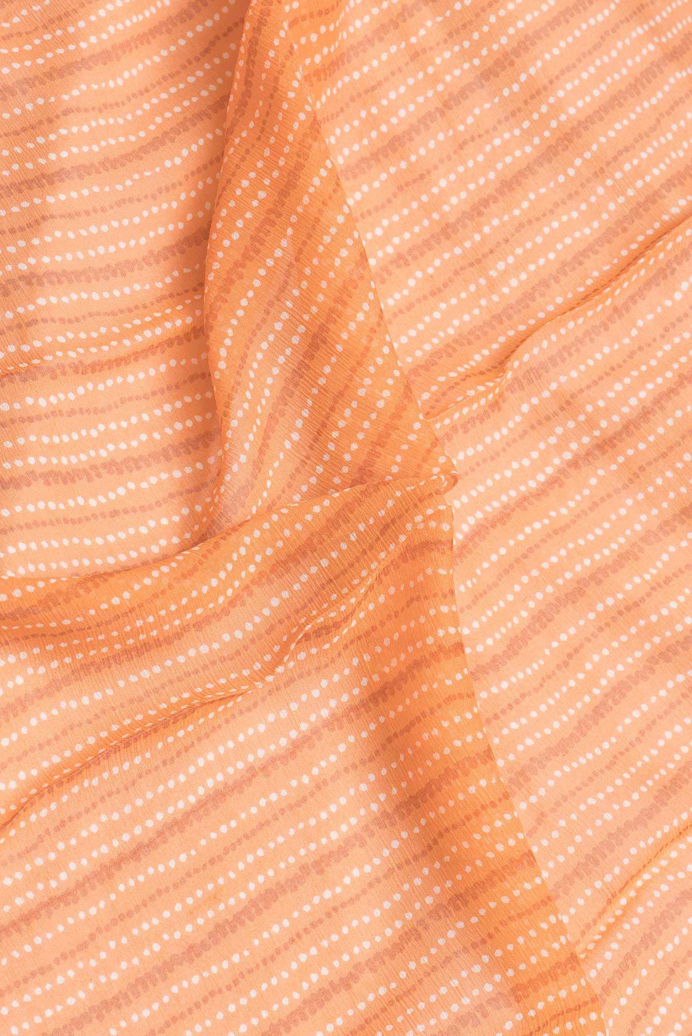 Close up of Peach Dual Tone Chiffon Saree with Printed design on the body and Zari Border.  displaying folds