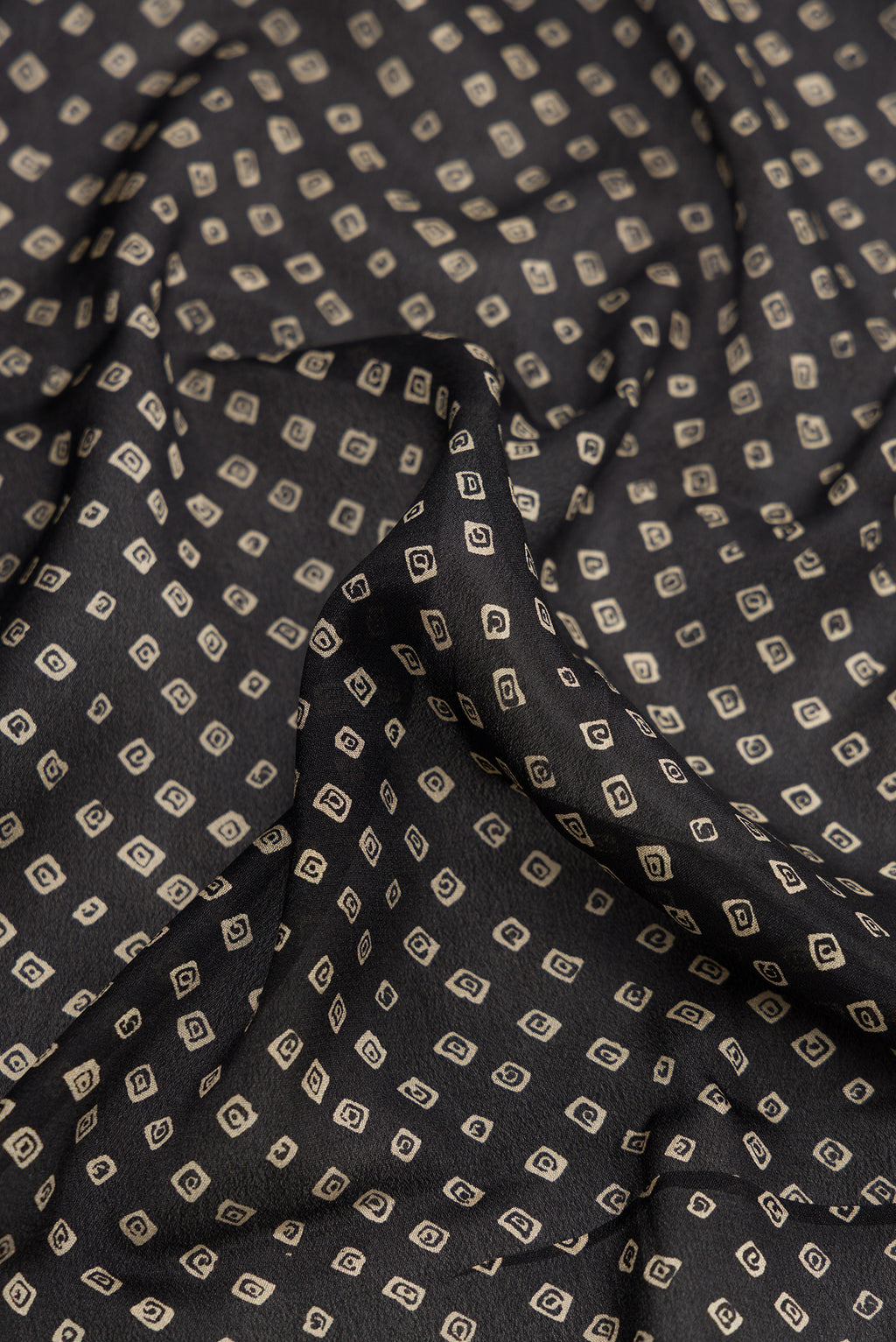 Close up of Black Dual Tone Mysore Crepe Saree with Bandhani Print on the body and Zari Border.  displaying folds