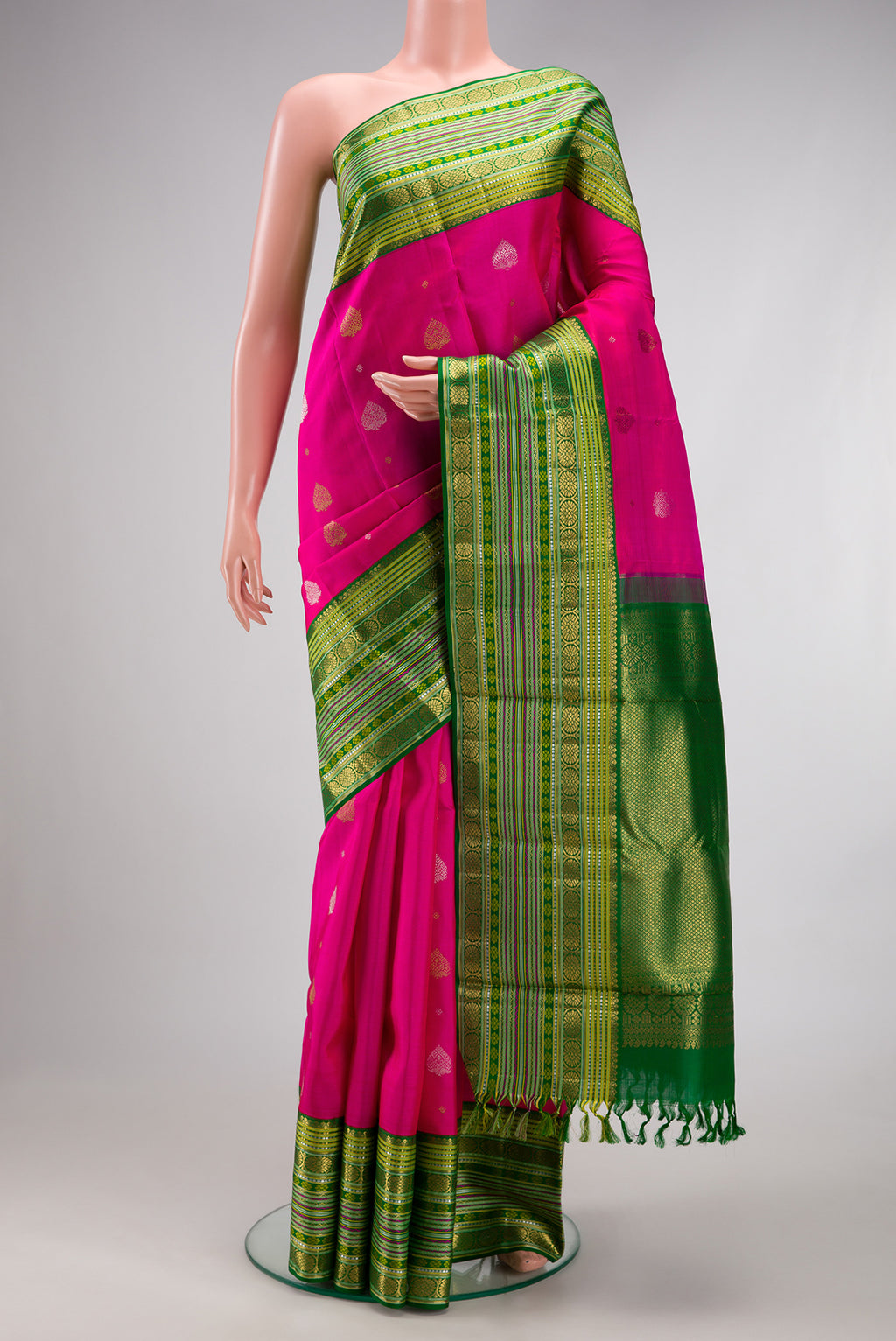 Pure Silk Pure Zari Rani Pink Kanchipuram Saree with Zari Butta on the body and Zari Border.  displayed on a mannequin